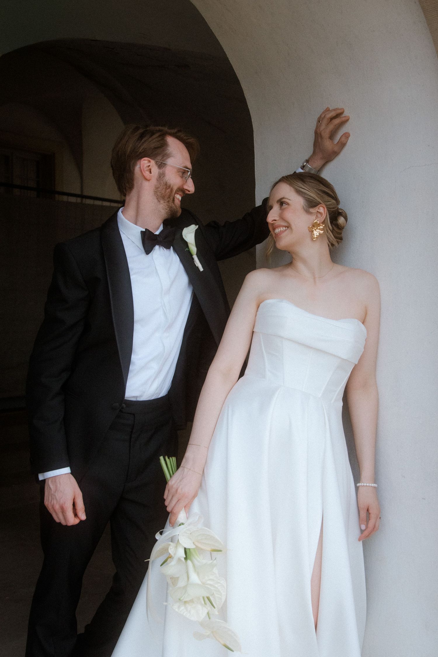 Candid wedding moments captured in an arched colonnade setting.