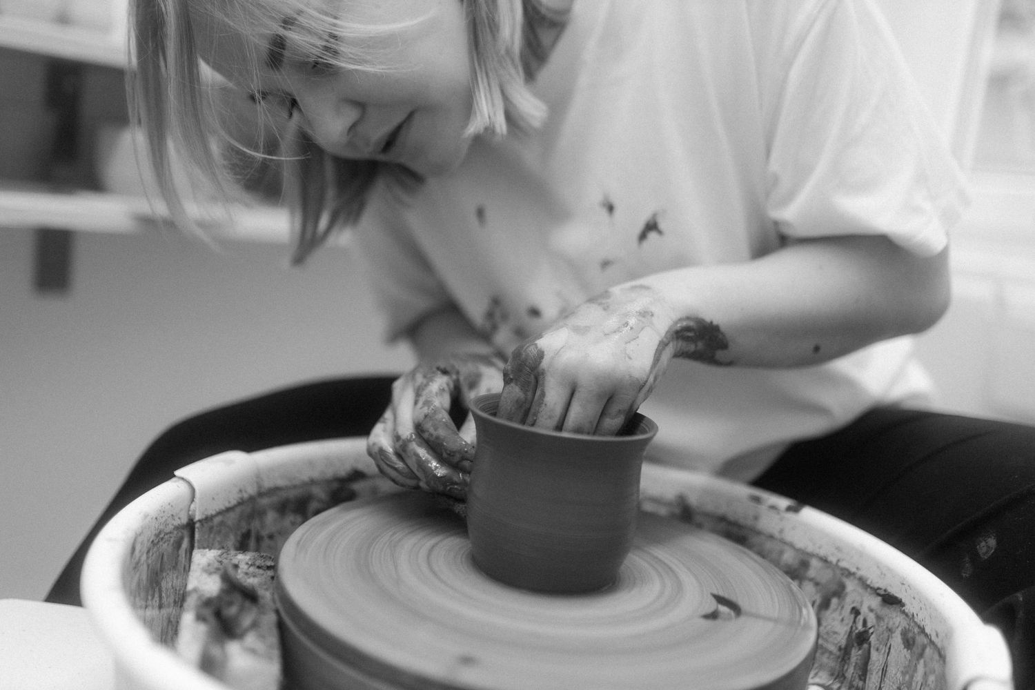 Close-up black and white photographs of food being prepared and plated in a professional kitchen setting.