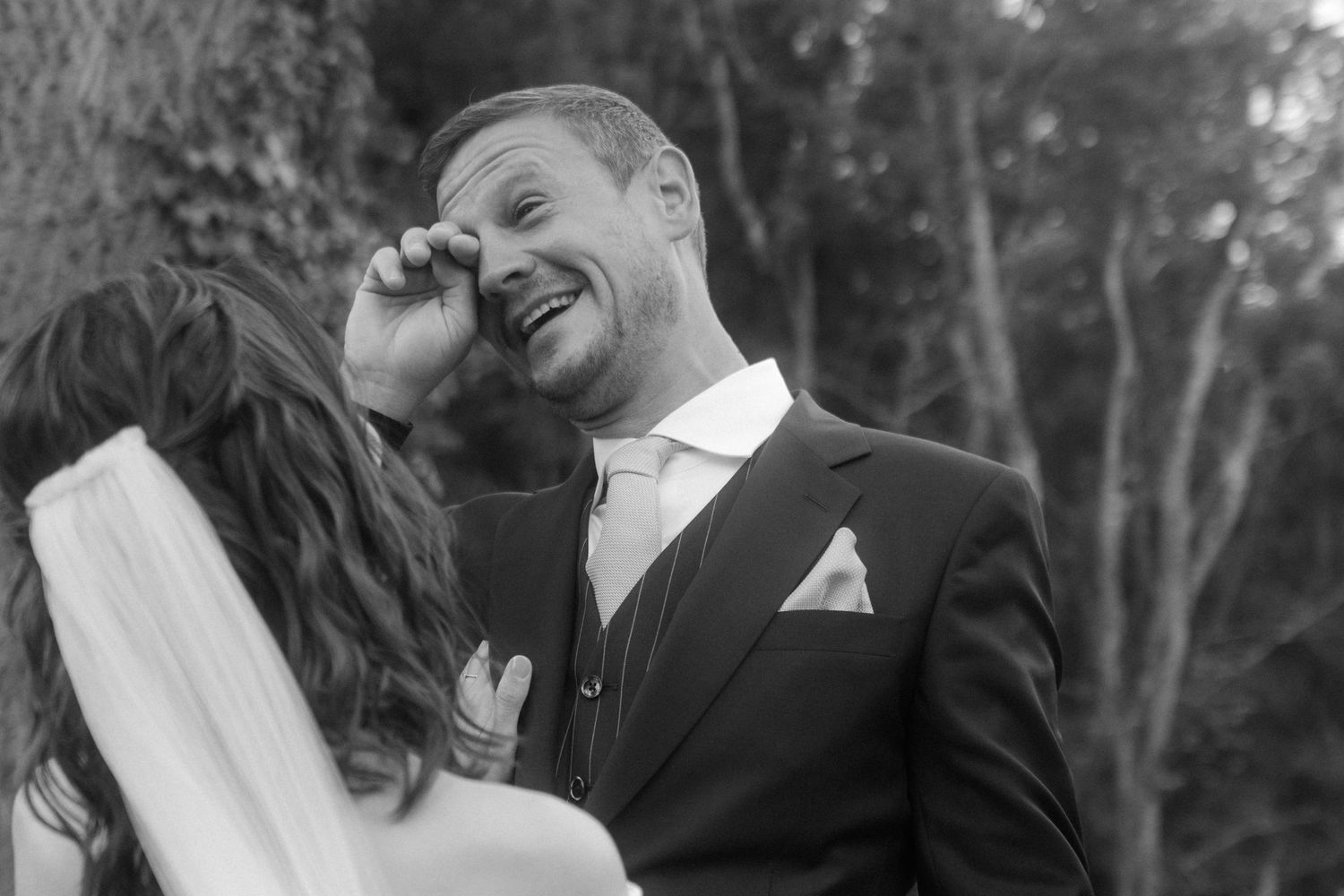 A tender black and white wedding photo capturing a couple's intimate laughter.