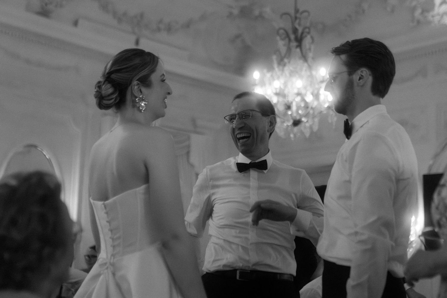 Black and white candid shots of dancing and celebration at an elegant wedding reception.