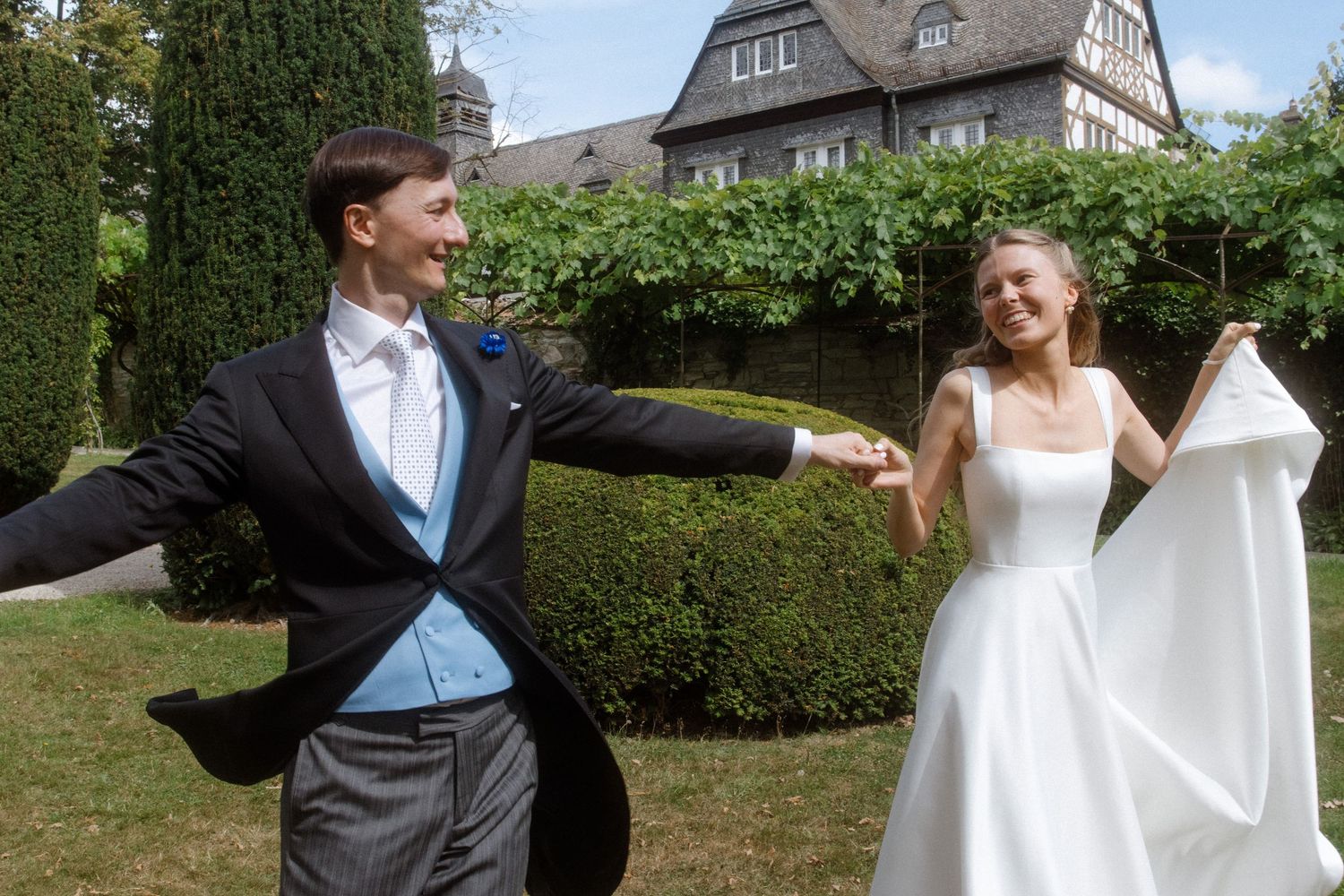 Wedding couple poses for photos in front of a traditional German-style house.