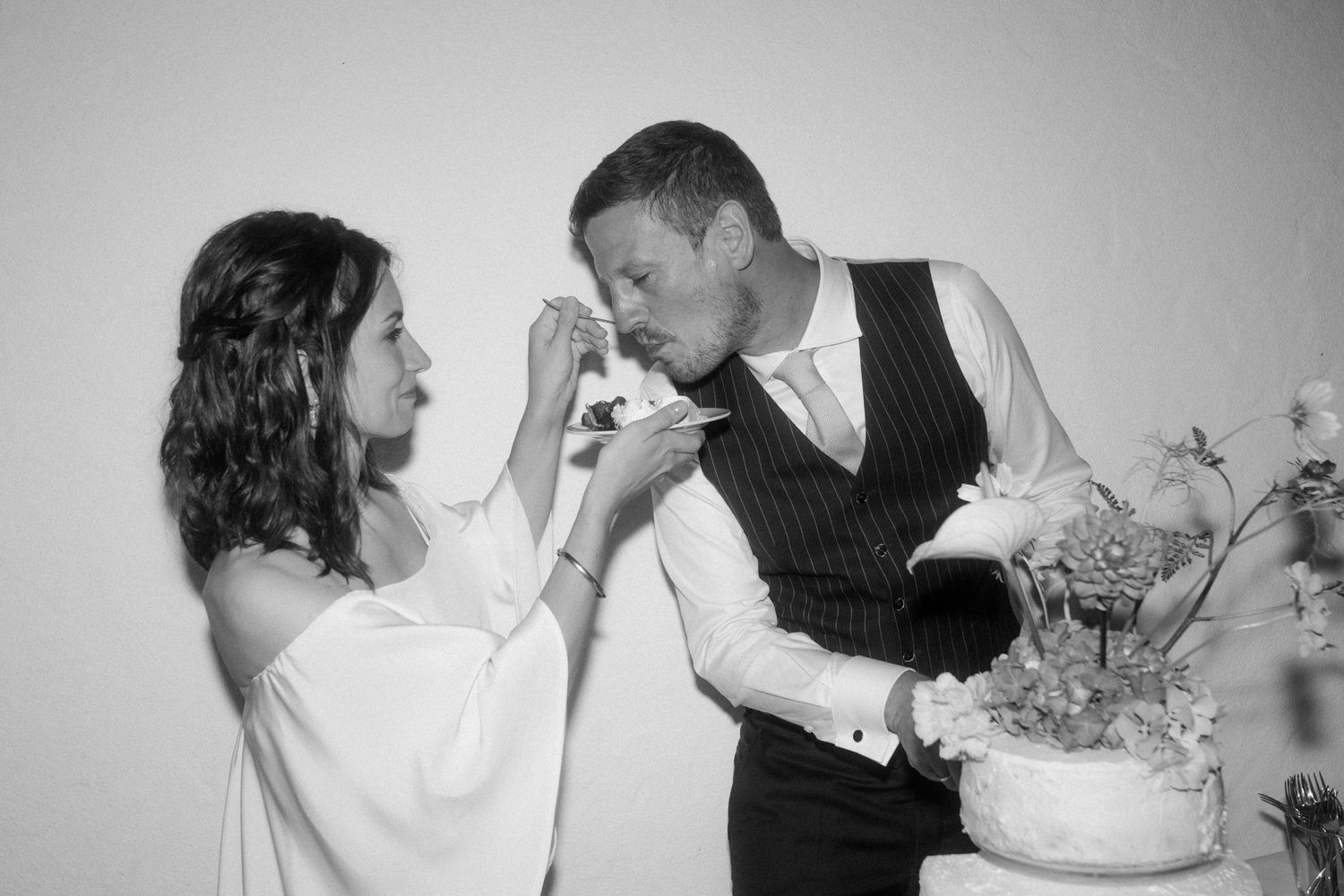 A playful moment during cake cutting at a wedding reception.