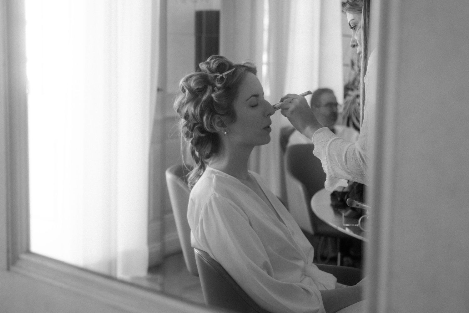 Black and white getting ready photos in a bright window-lit room.