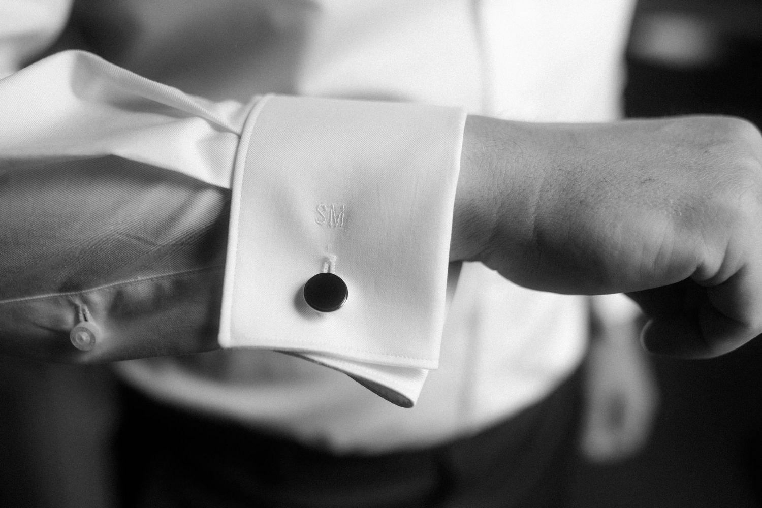 Abstract black and white image showing hands adjusting formal attire.