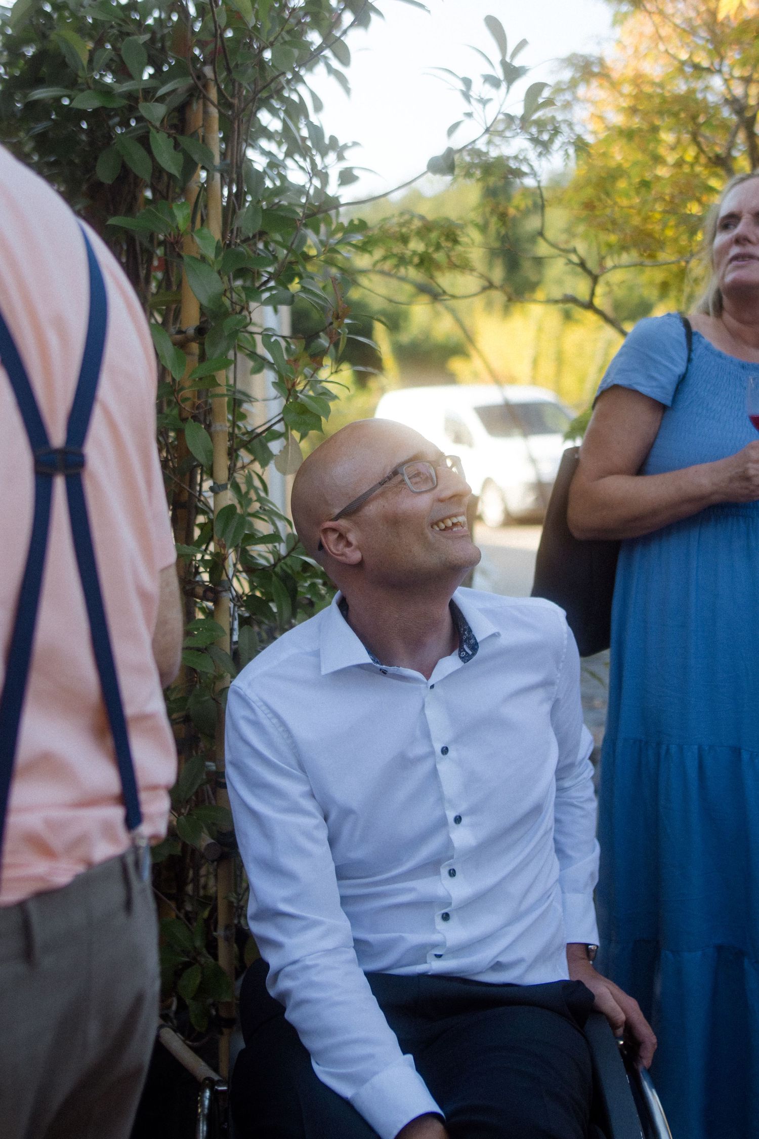 Candid moment of wedding guests chatting in an outdoor garden setting.