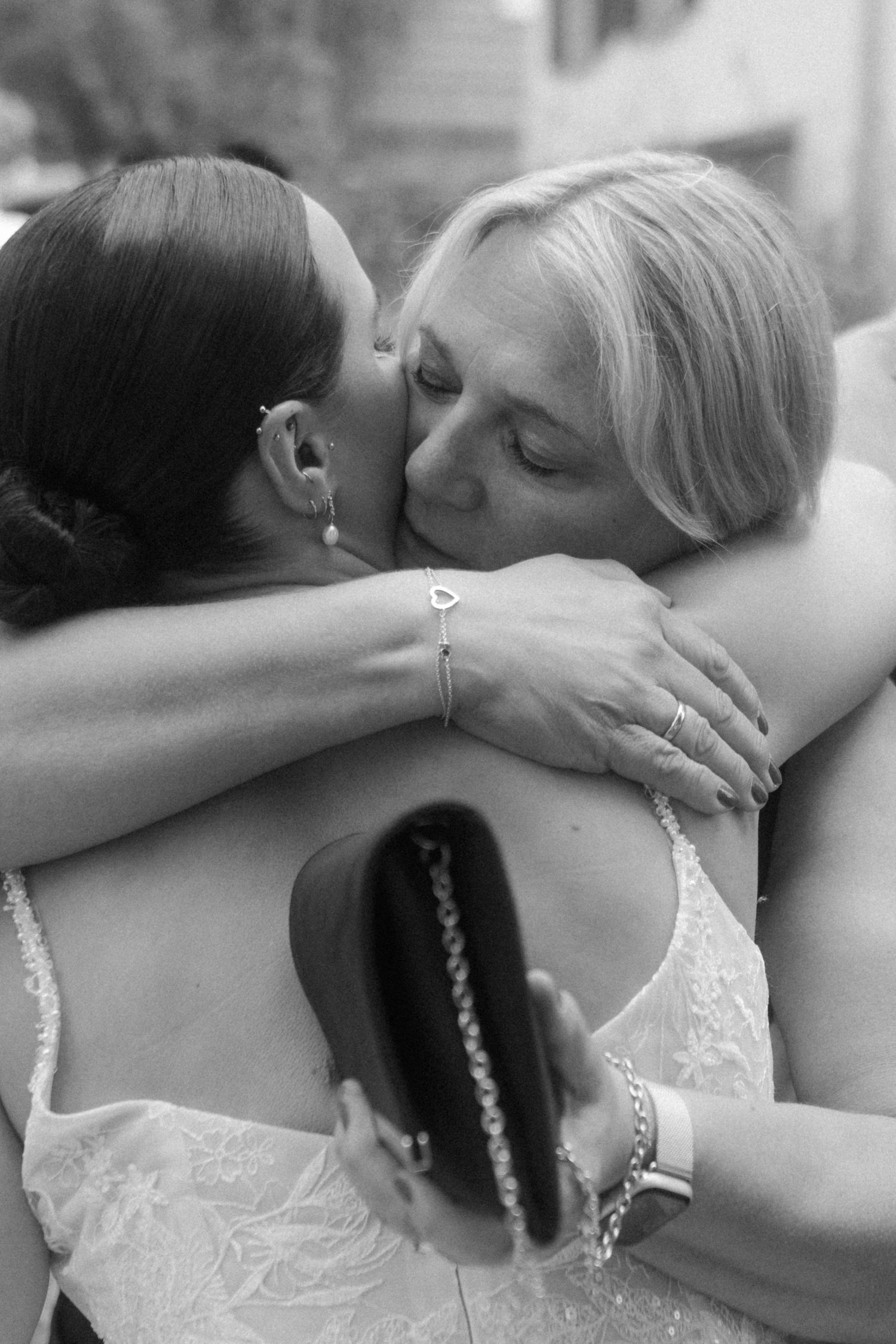 Emotional embrace captured in black and white during wedding celebration.
