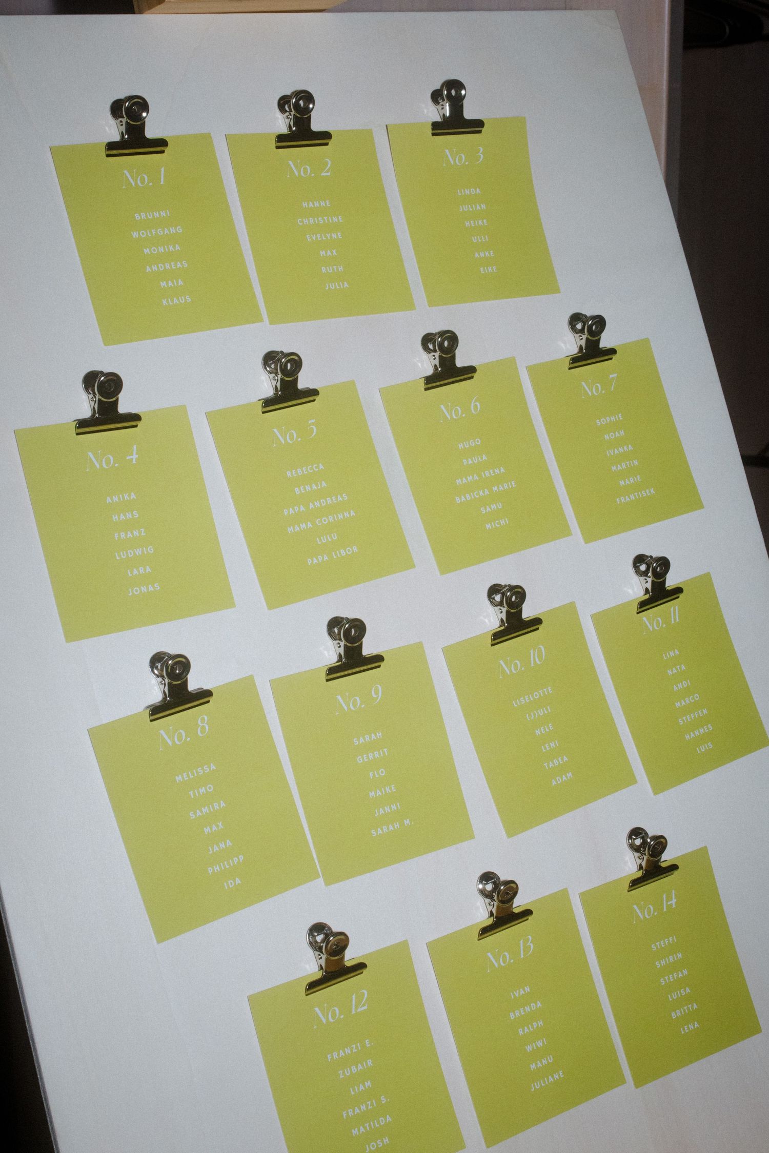 Yellow seating chart cards arranged in rows with metal bulldog clips.