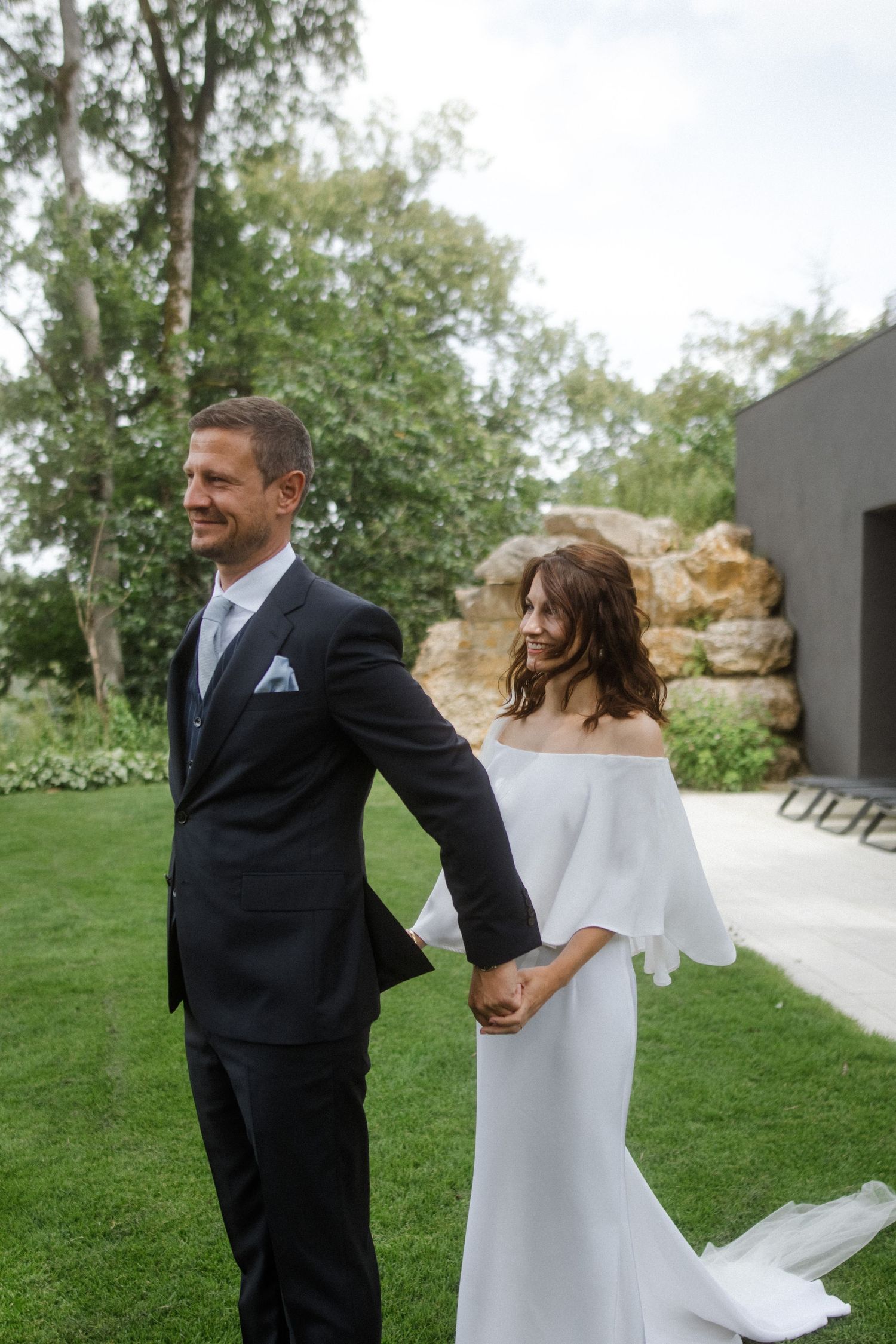 A couple shares a romantic first look moment in an elegant garden setting on their wedding day.