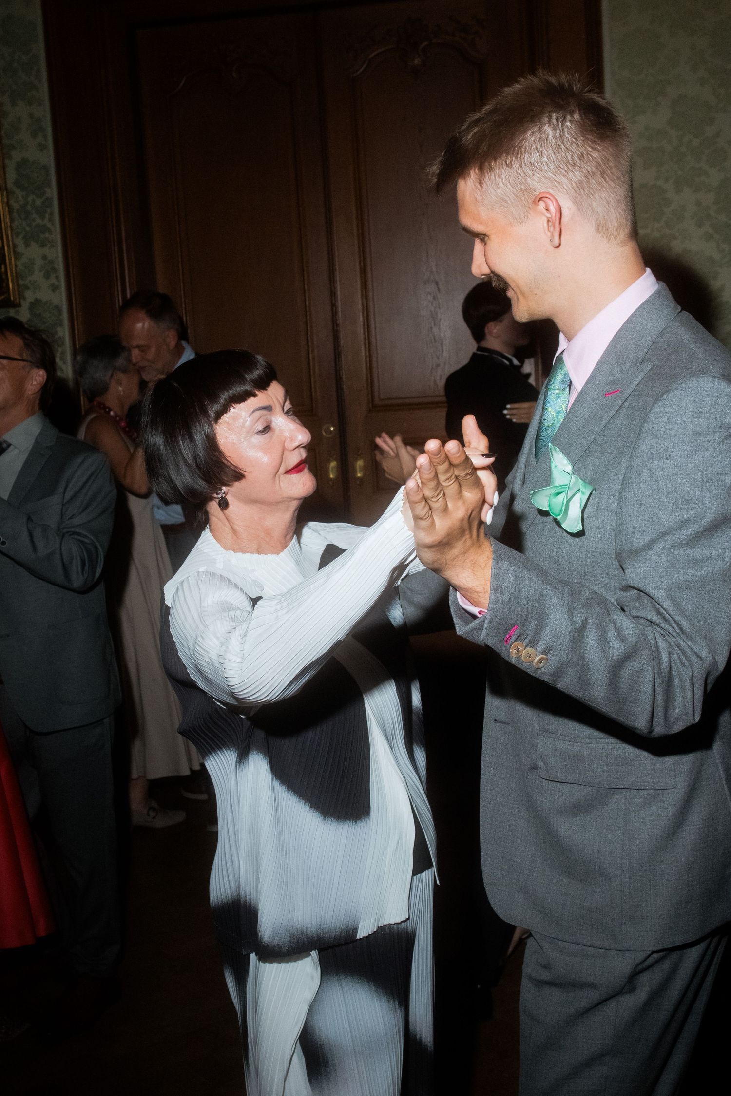 Dancing partners in formal attire sharing a joyful moment on the dance floor.