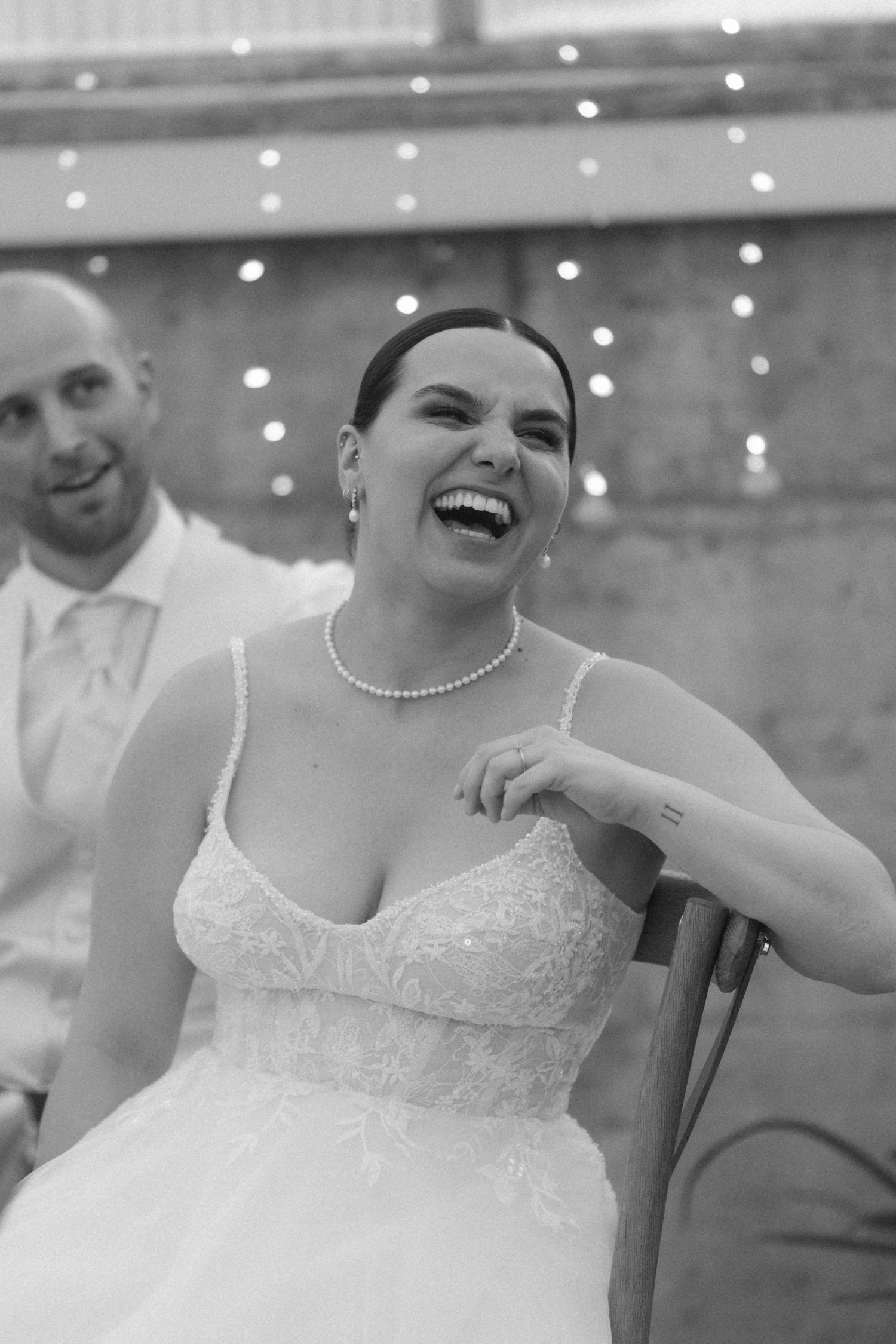 A joyful moment during a wedding reception with soft lighting and decorative fairy lights.
