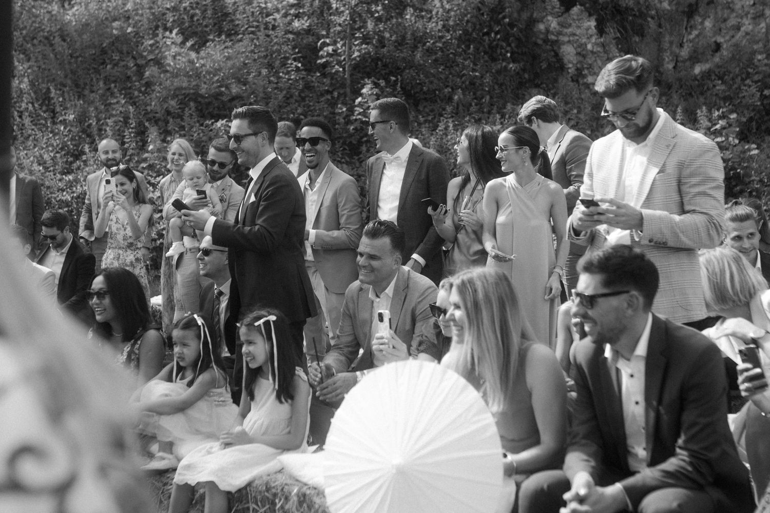Vintage black and white photo of wedding guests gathered outdoors.