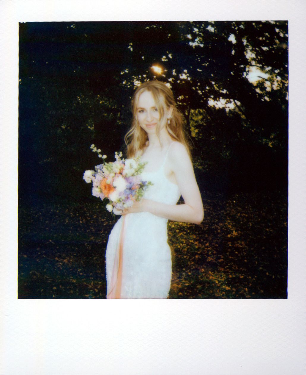 Wedding couple shares an intimate moment in a garden with soft lighting and delicate floral bouquet.