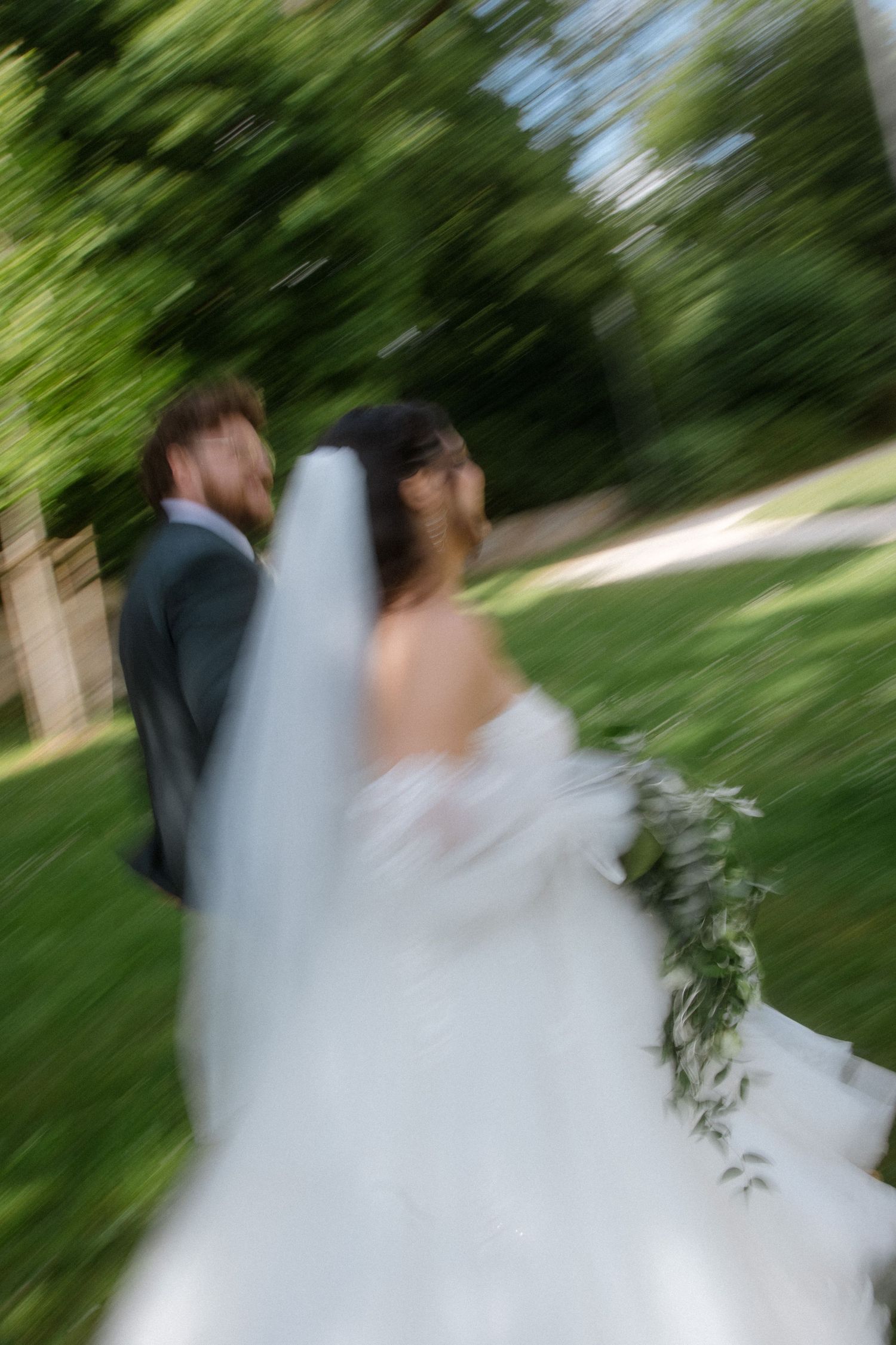 Motion-blurred artistic wedding photo in a garden setting.