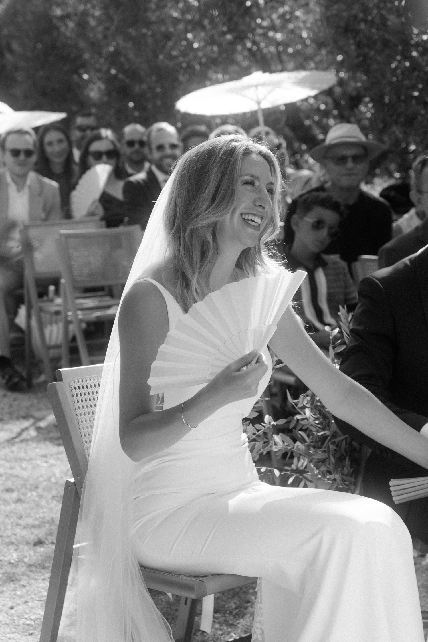 Wedding celebration in a garden setting with white parasols and joyful moments.