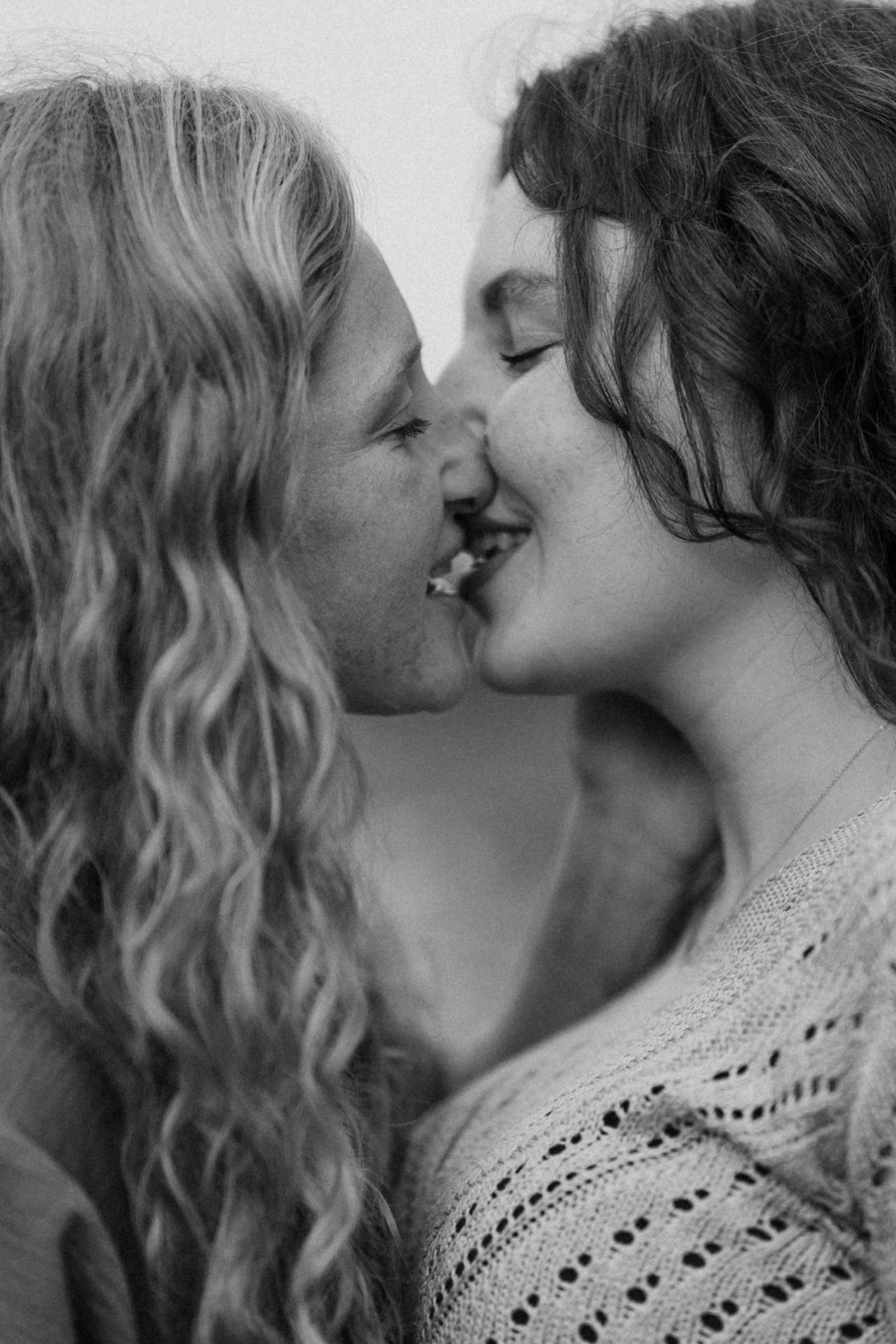 Black and white close-up portrait of an intimate romantic moment.