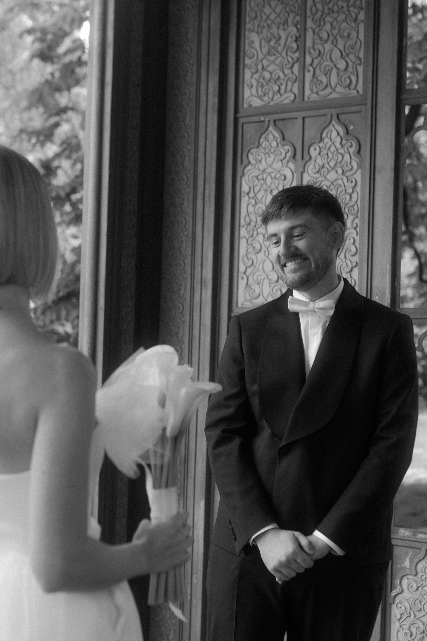 Wedding couple sharing a first look moment in front of ornate doors.