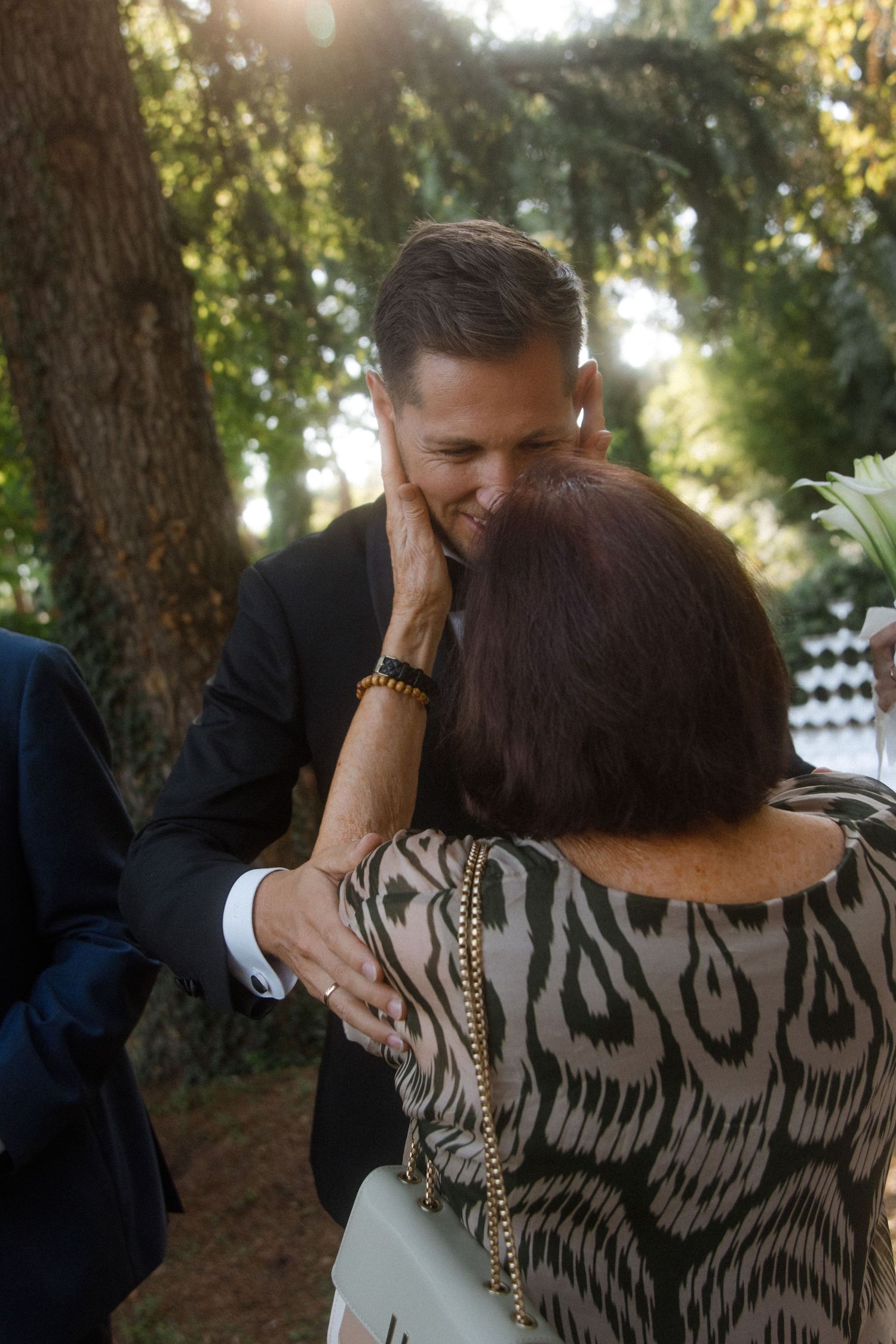 Warm greetings exchanged at outdoor garden celebration.