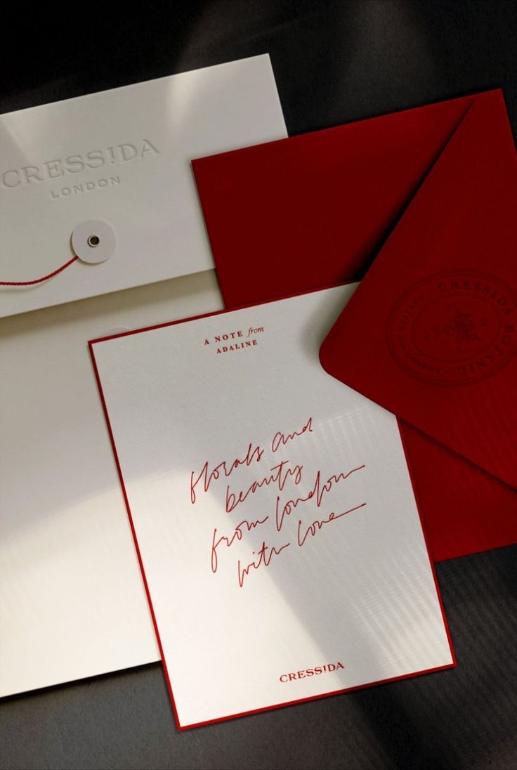 Elegant white and red stationery with handwritten cursive text from Cressida London.
