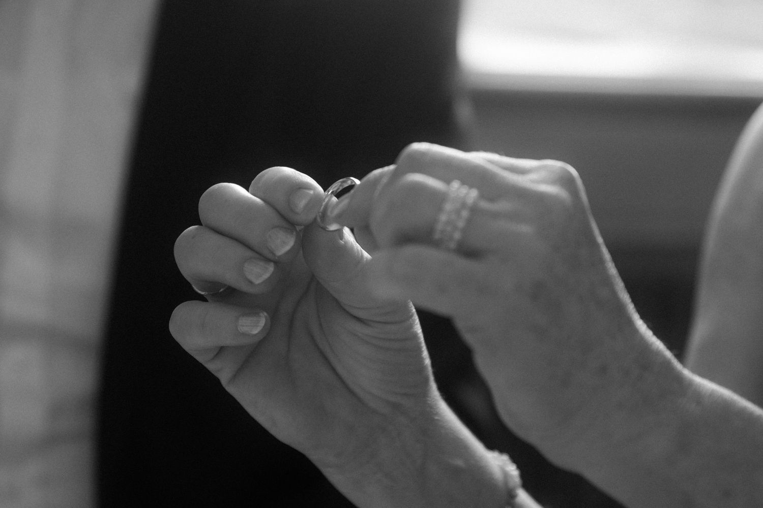Close-up black and white photo of hands with rings in an artistic composition.