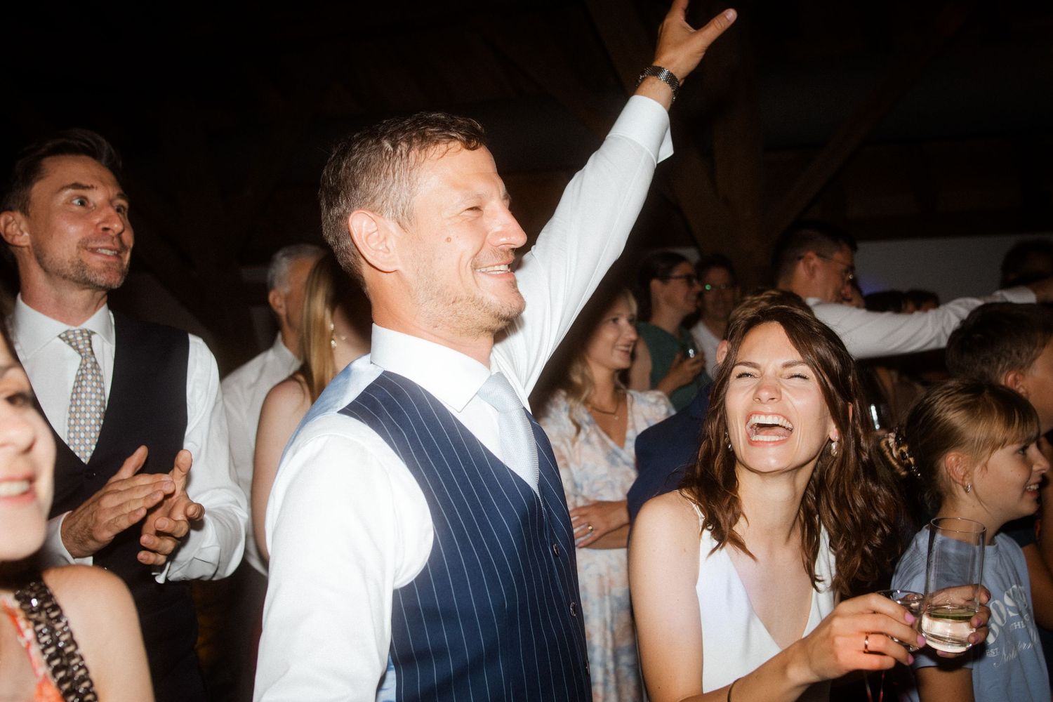 Wedding guests celebrating and dancing at a lively reception party.