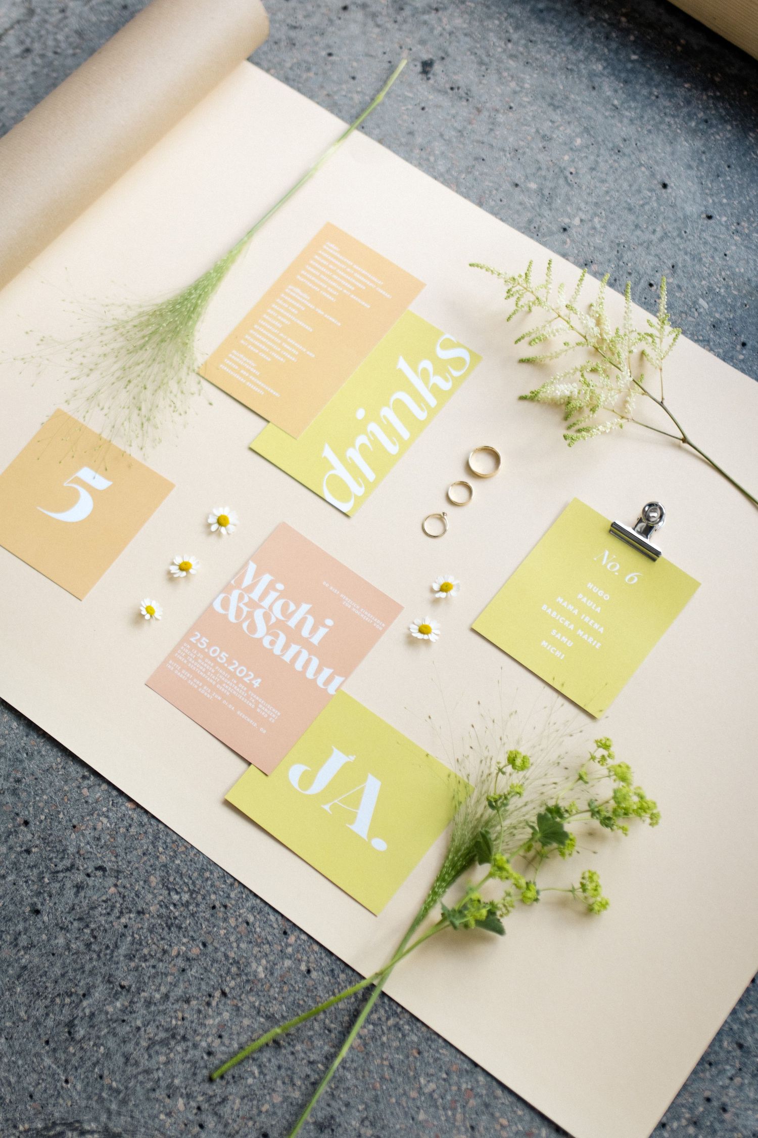 Modern wedding invitation design with soft yellow and pink color blocks and botanical accents.