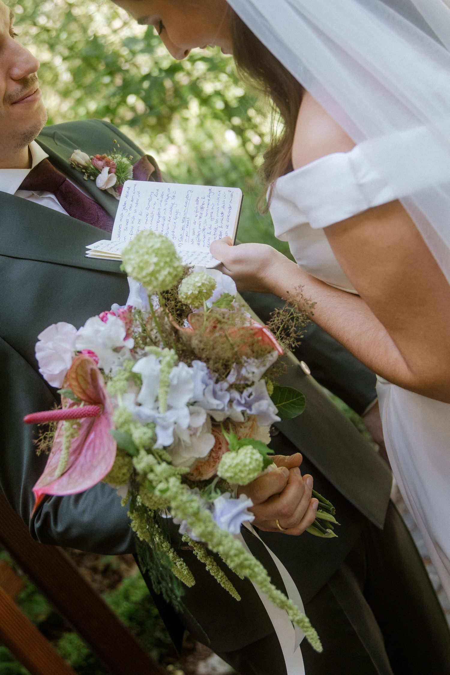 Close-up of elegant wedding bouquet featuring pink and white flowers with greenery accents.