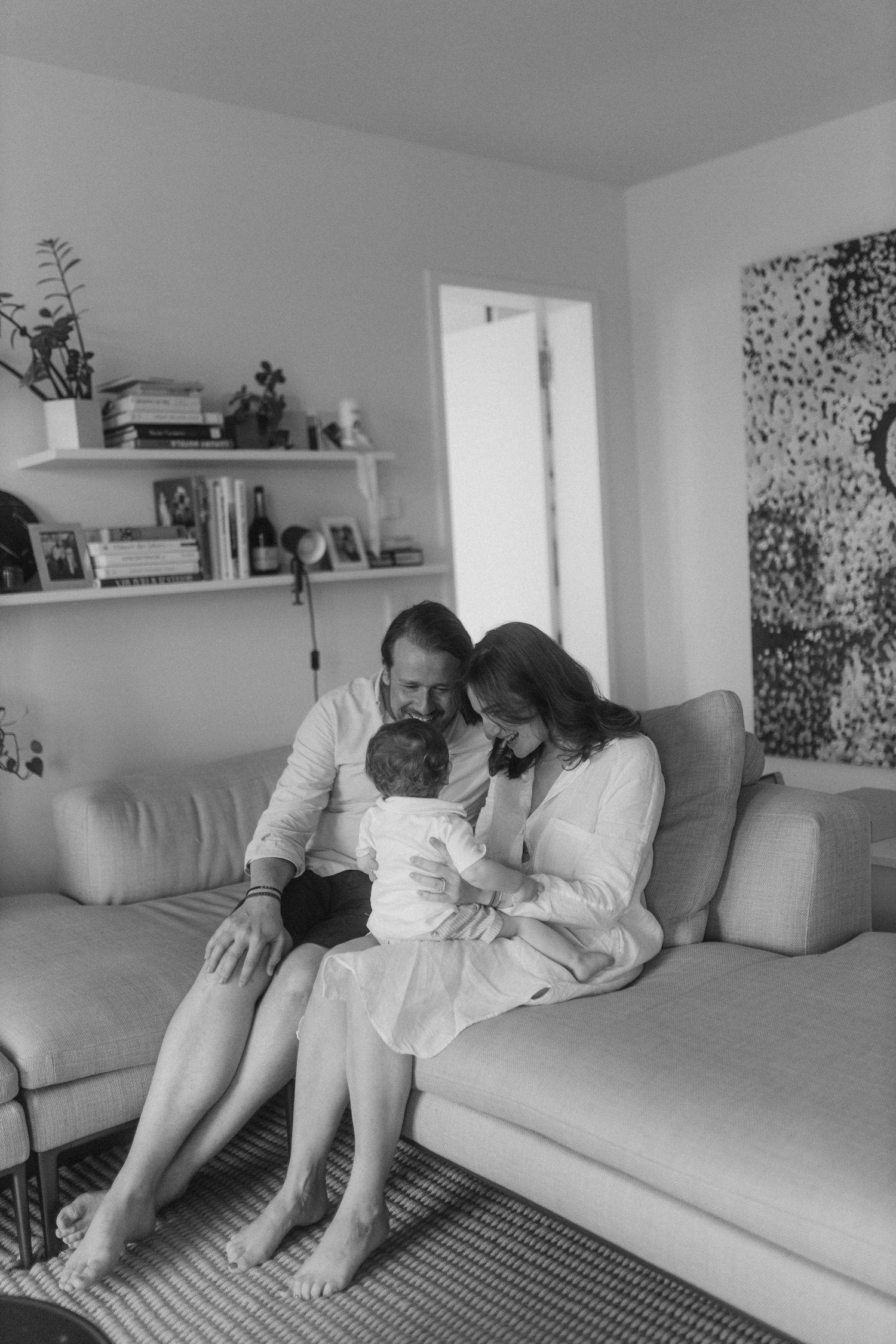 Family lounging together on a gray couch in a modern living room.