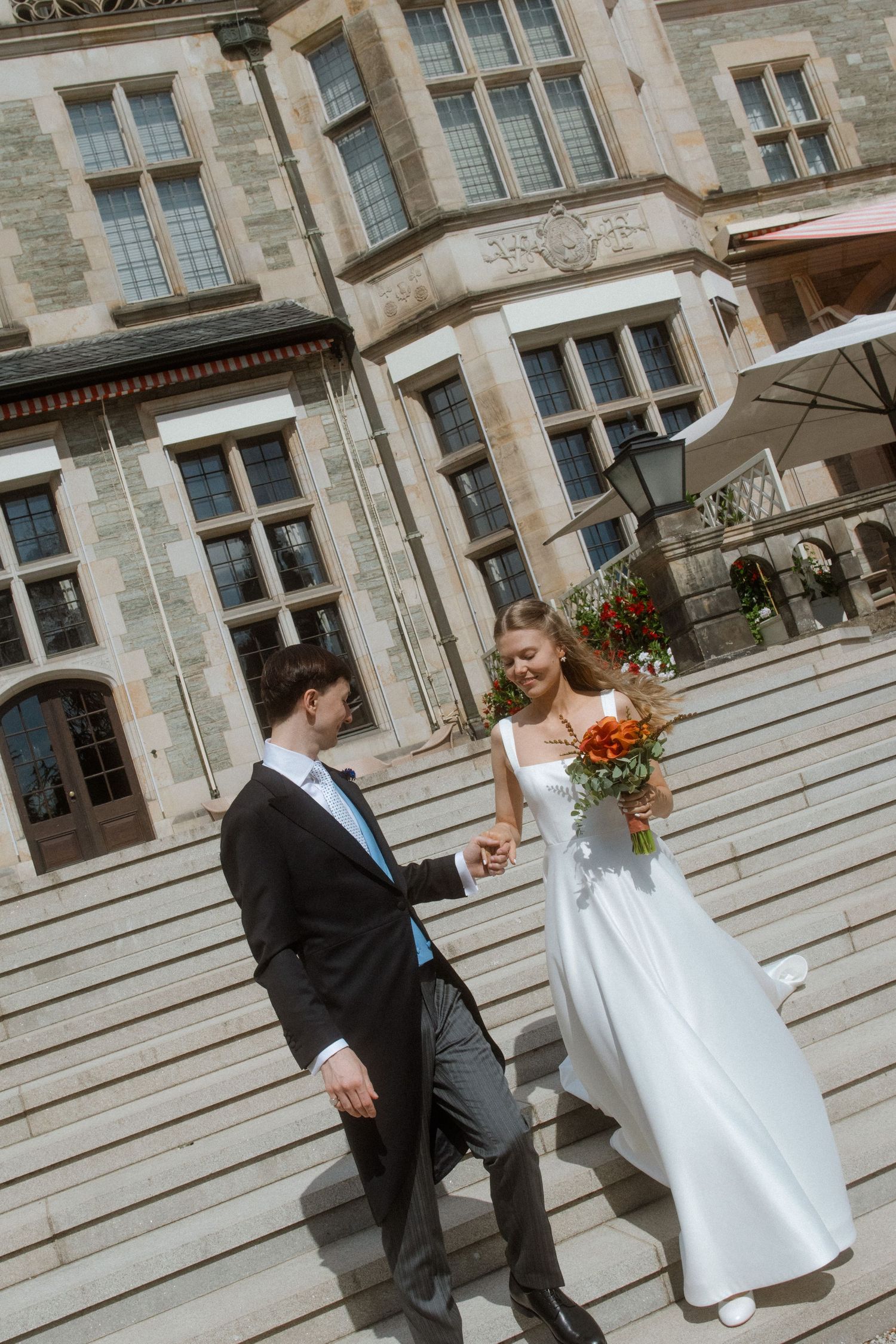 Wedding photographs taken on grand stone steps of a historic estate building.