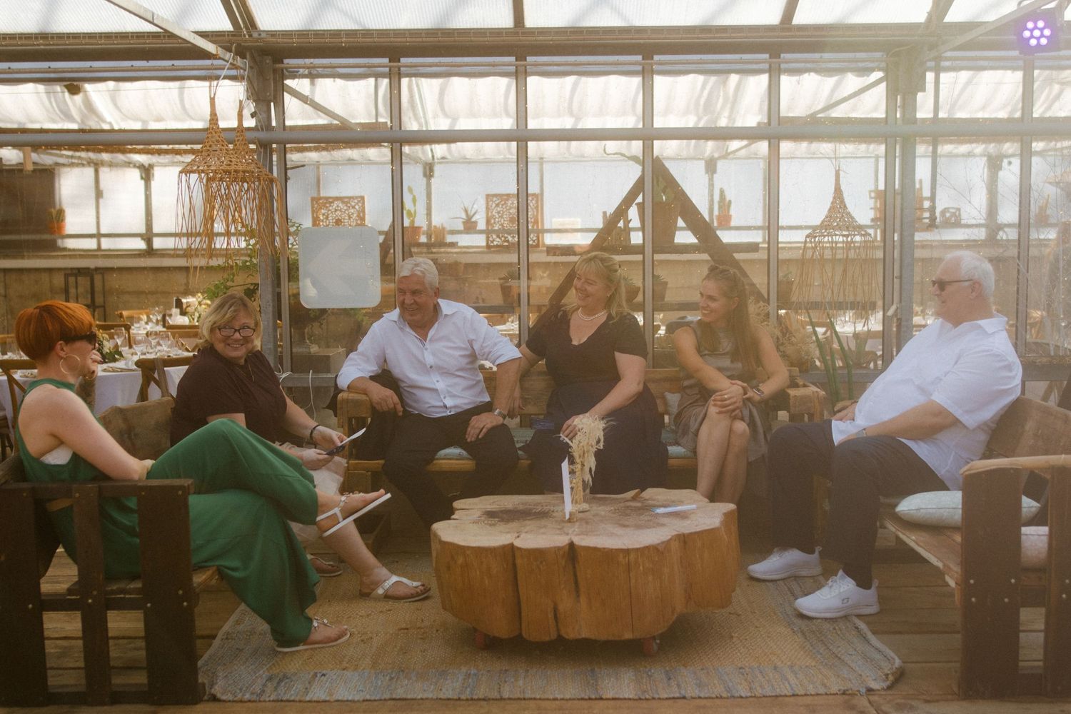 Group gathered on outdoor patio furniture during sunset at reception venue.