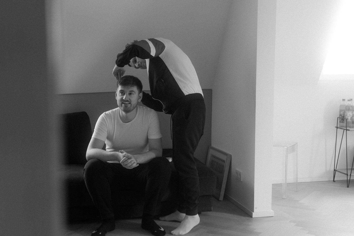 A black and white photo capturing a relaxed styling preparation moment.