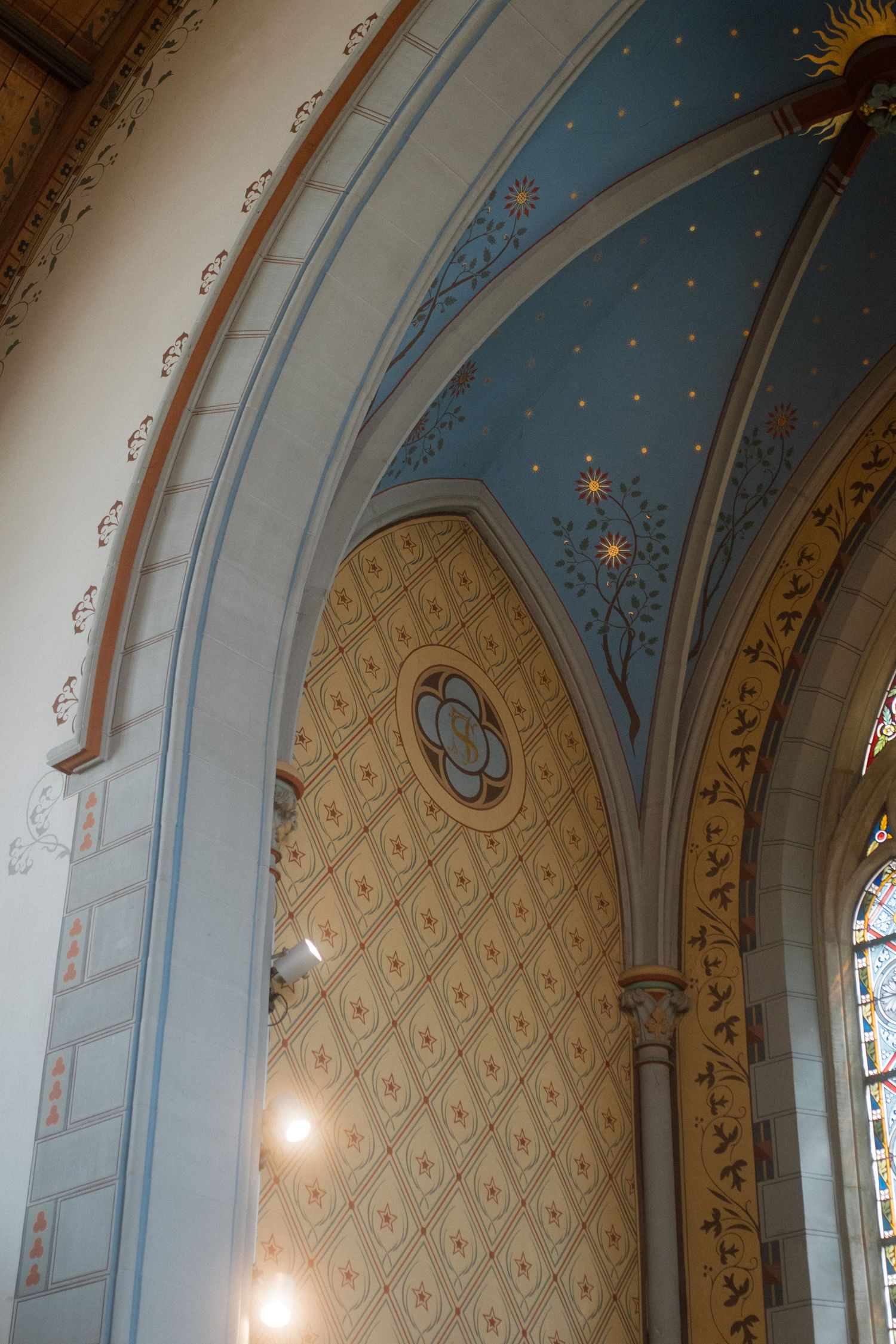 Ornate church ceiling with blue painted details and decorative arches.