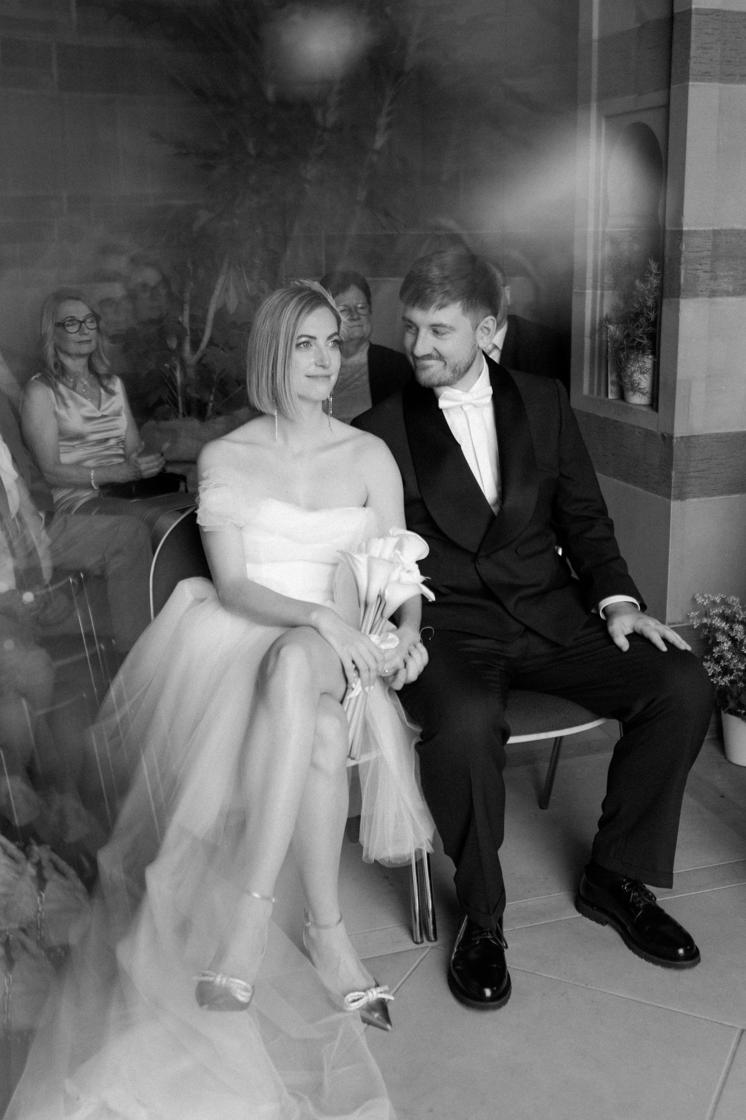 Artistic black and white wedding photo showing couple sitting together with blurred motion effect.
