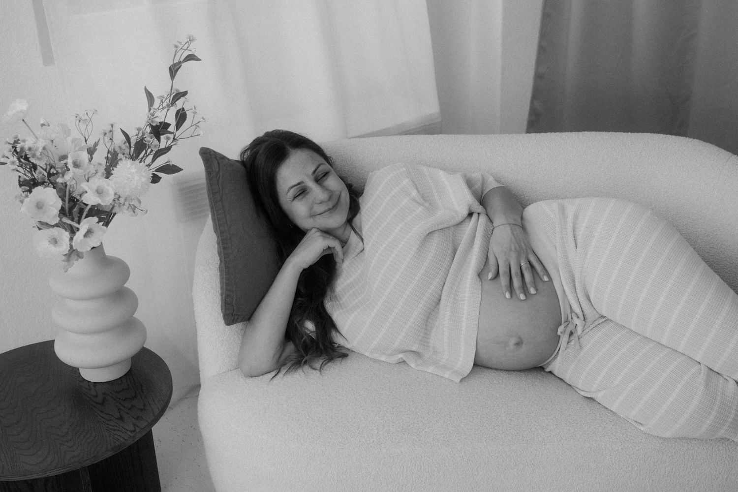 Artistic black and white photo series showing someone resting on white bedding.