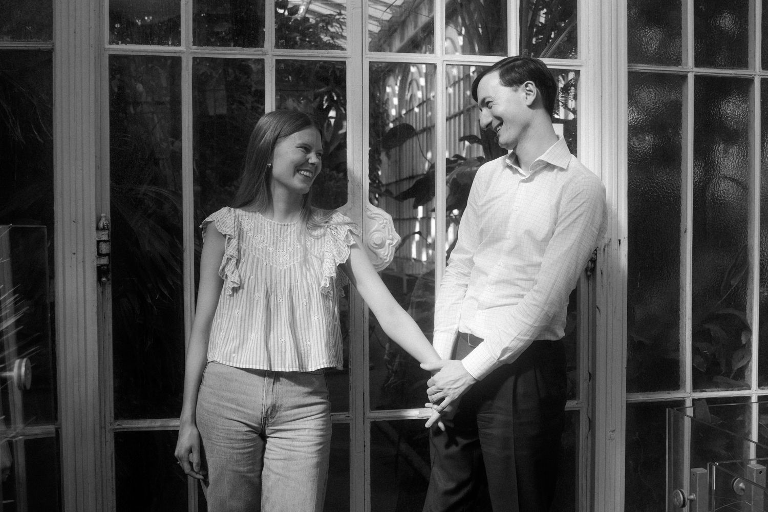 Black and white photo series showing people interacting near vintage window frames.