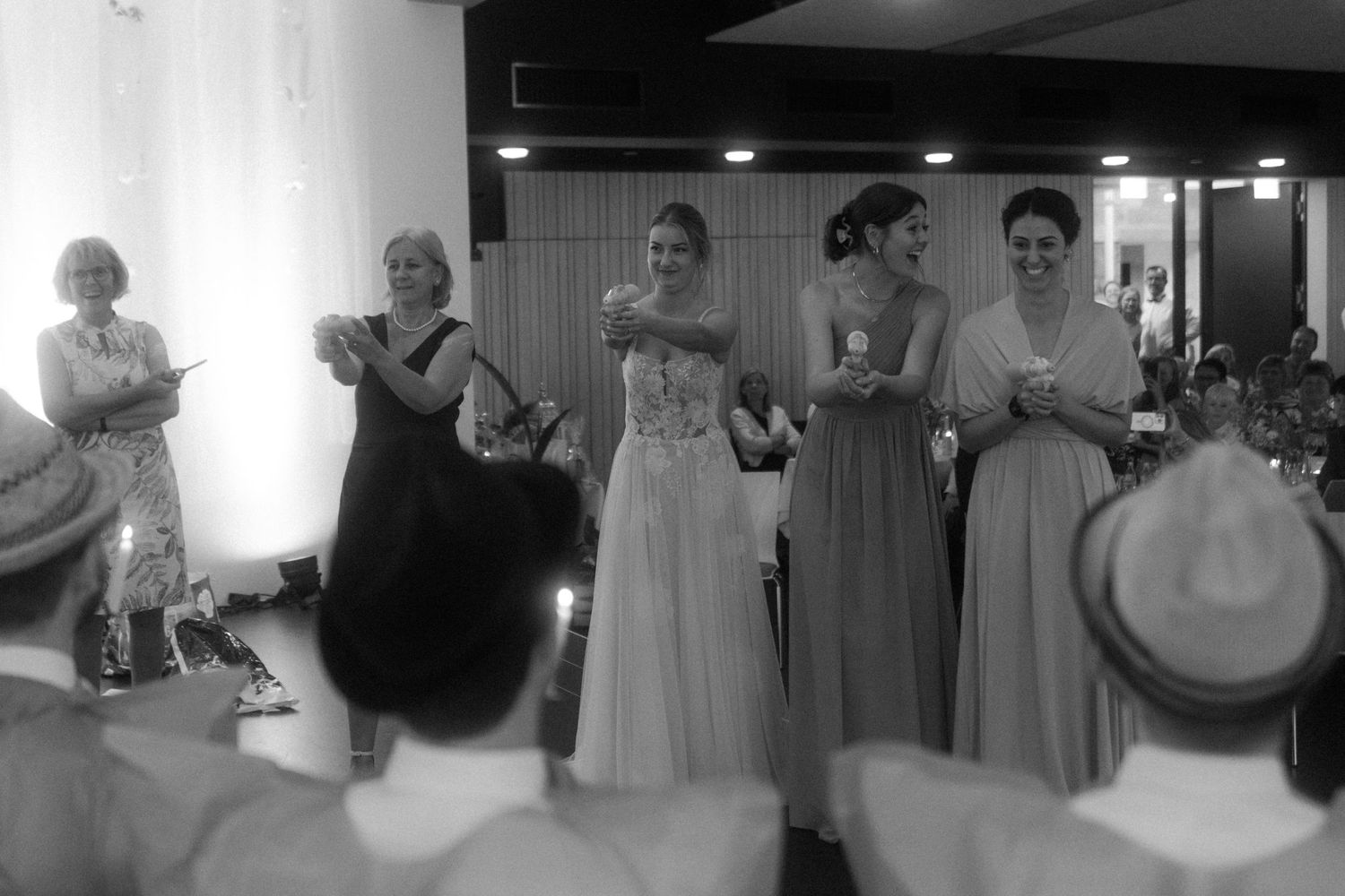 A group performs during a wedding reception in black and white.