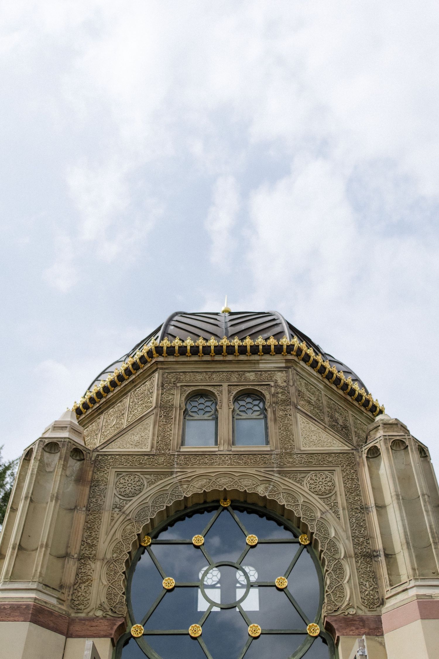 Ornate architectural detail of a domed building with arched windows and Islamic-inspired patterns.