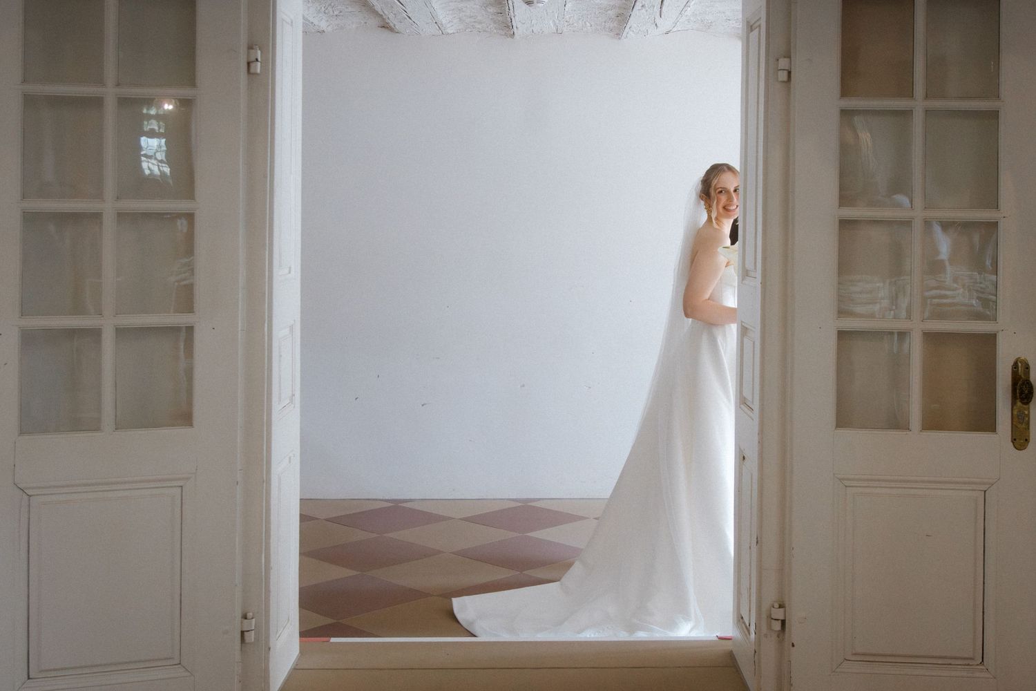 Silhouette of a bride in doorway with flowing white wedding dress.