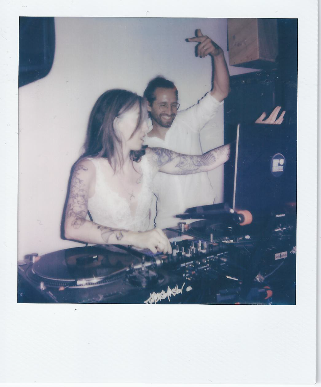 A DJ performs at a dimly lit venue with professional mixing equipment and turntables.