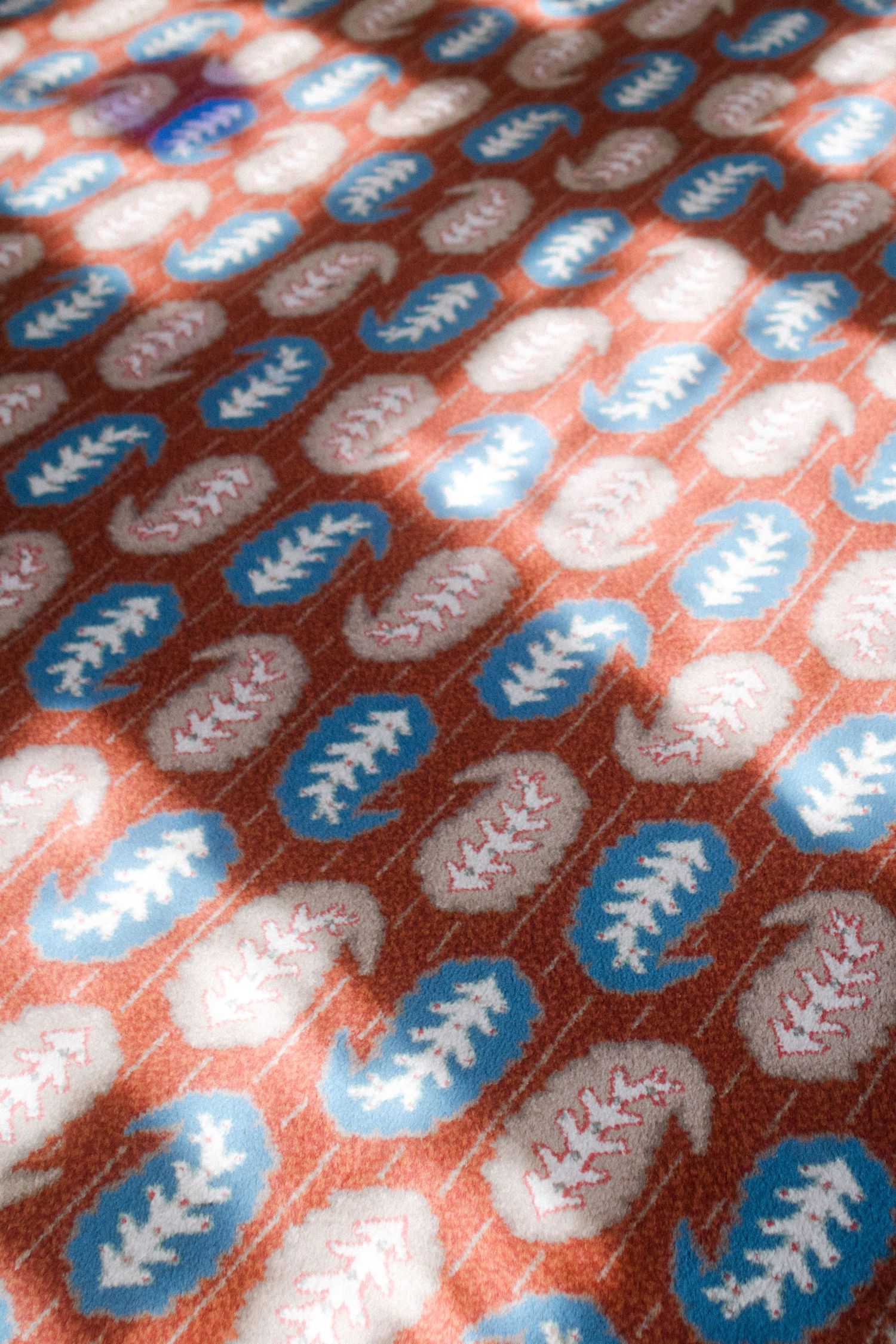 Close-up of a decorative pattern featuring blue and coral geometric designs.