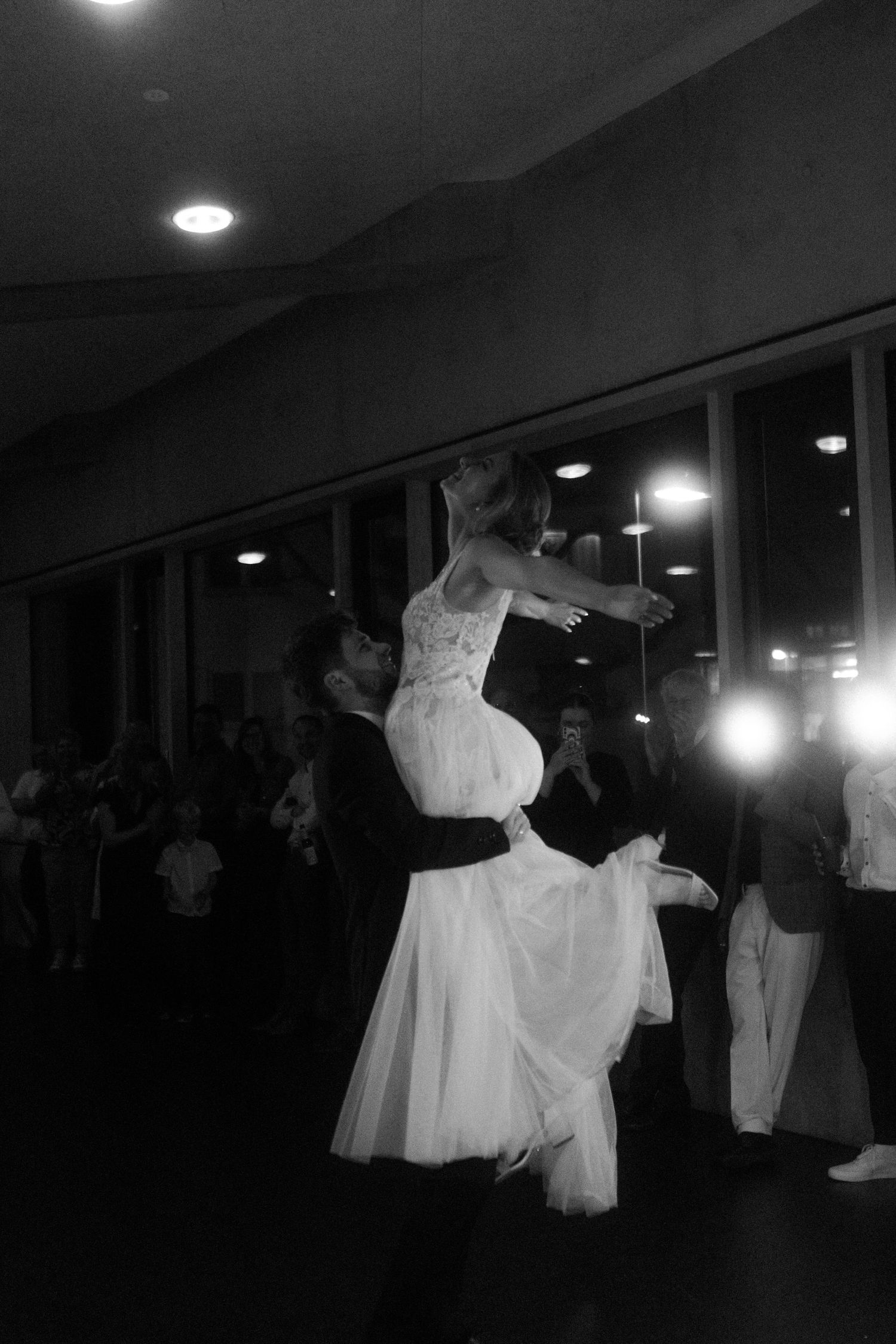 A dramatic black and white photo of an elegant wedding dance lift.