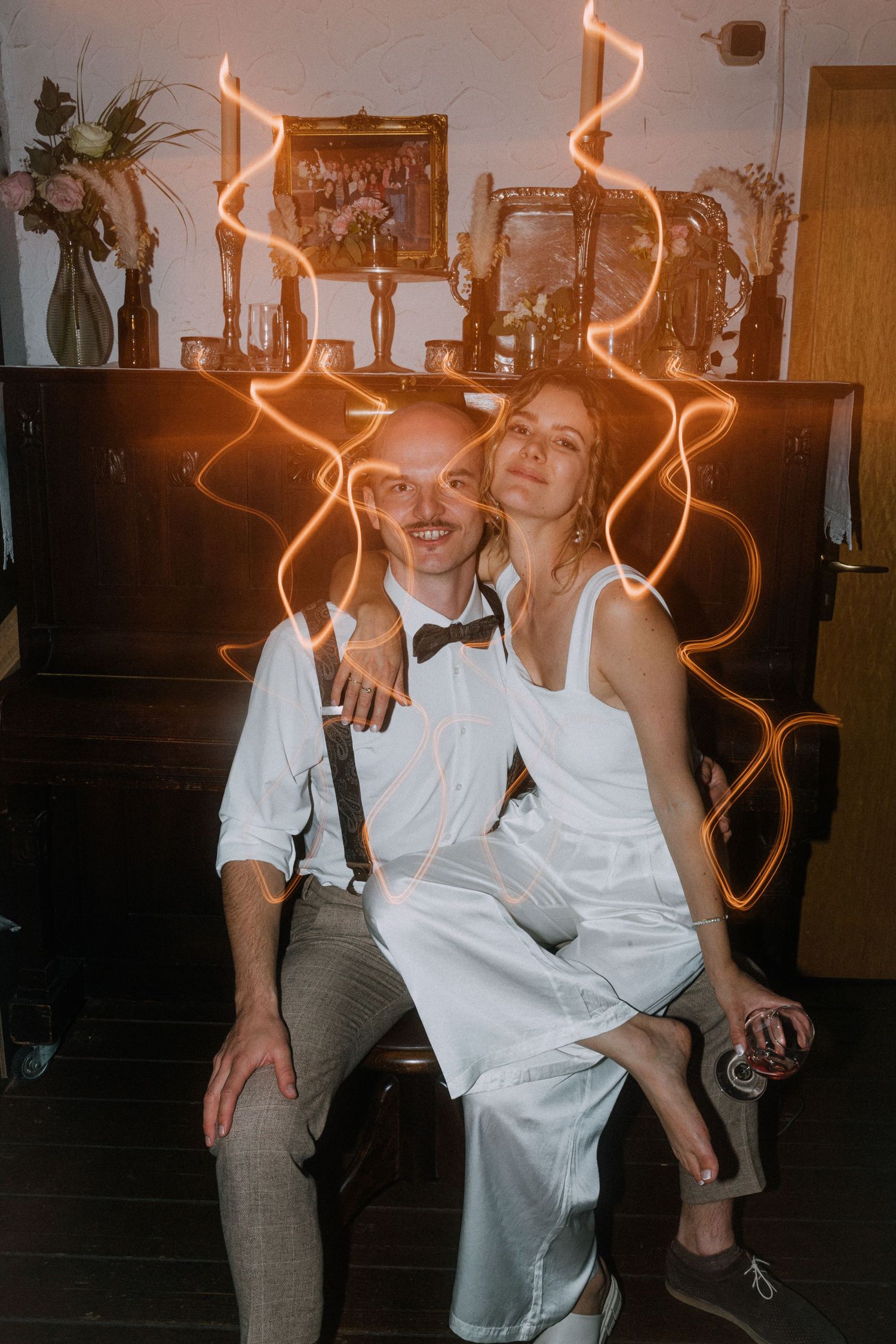 Wedding party dancing and celebrating with light trails creating a festive atmosphere at reception.