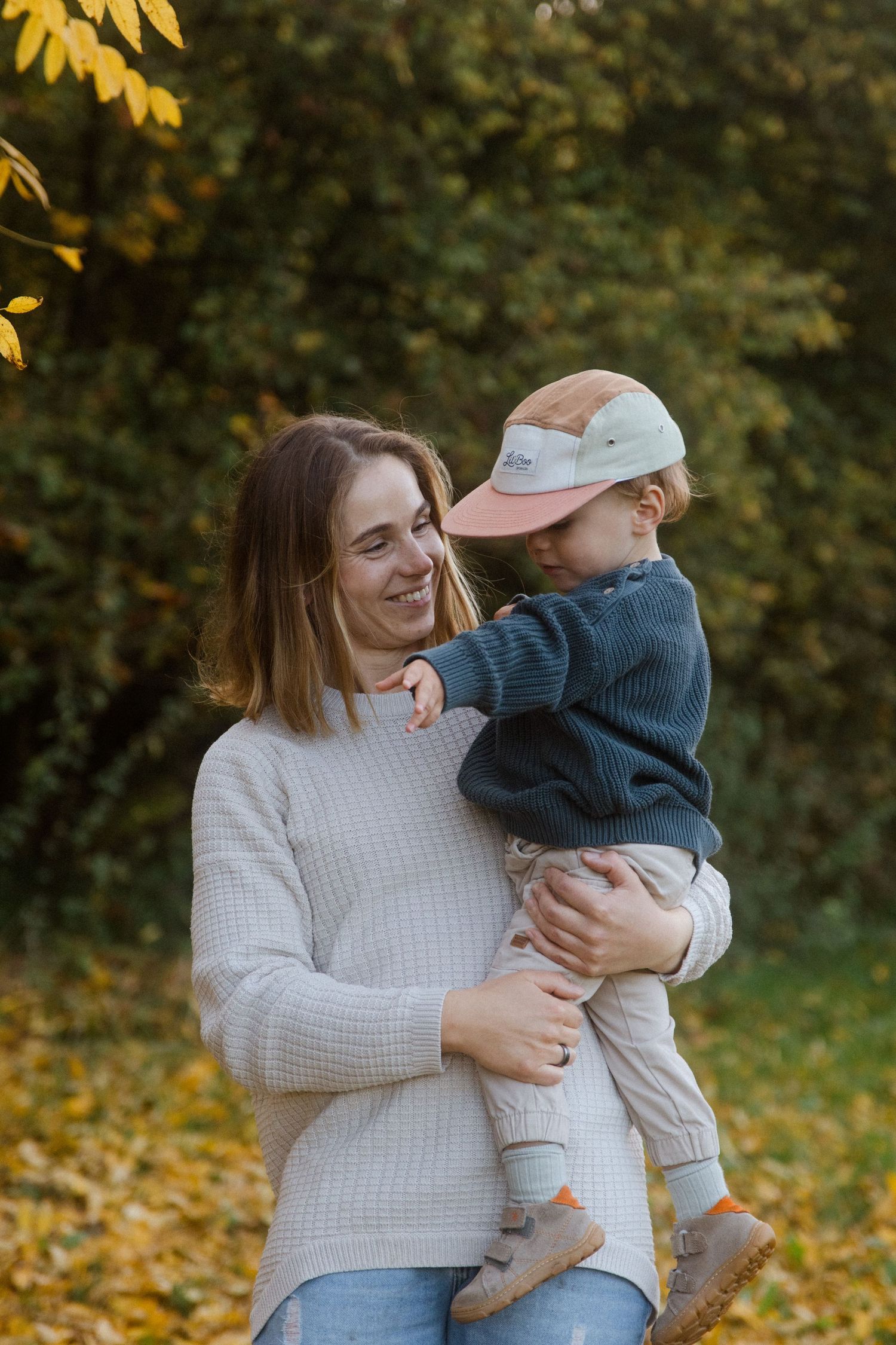 Family enjoying a playful moment together among yellow fall foliage.