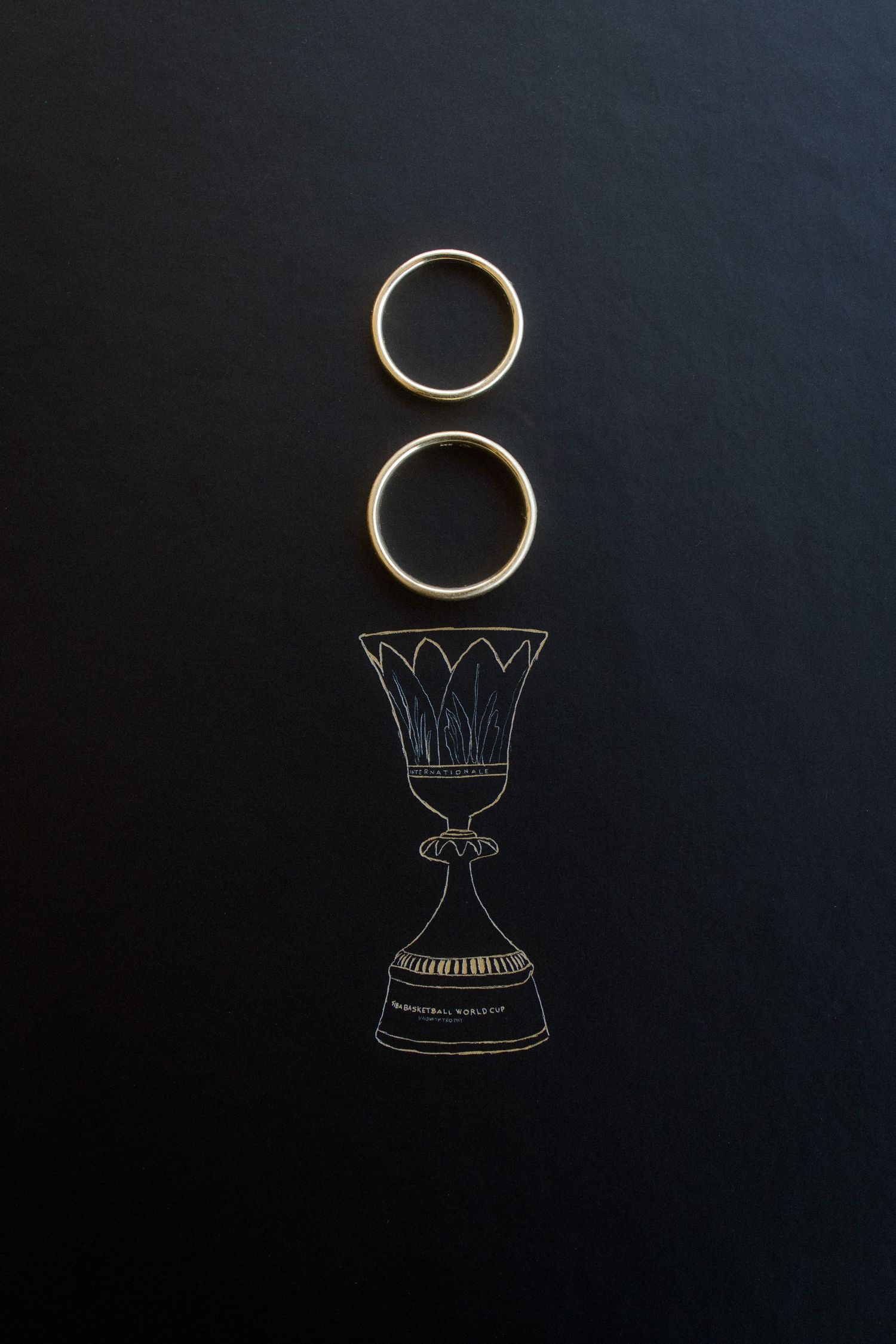 Creative wedding ring photo with hand-drawn chalked vase illustration on black background.