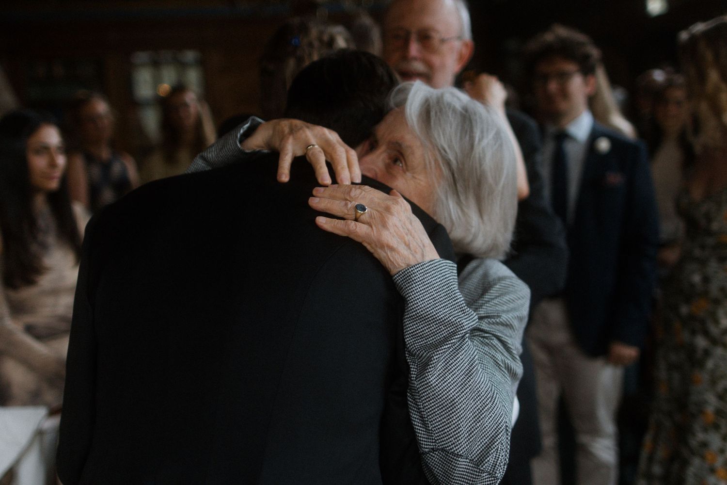 Guests sharing emotional embraces during wedding reception.