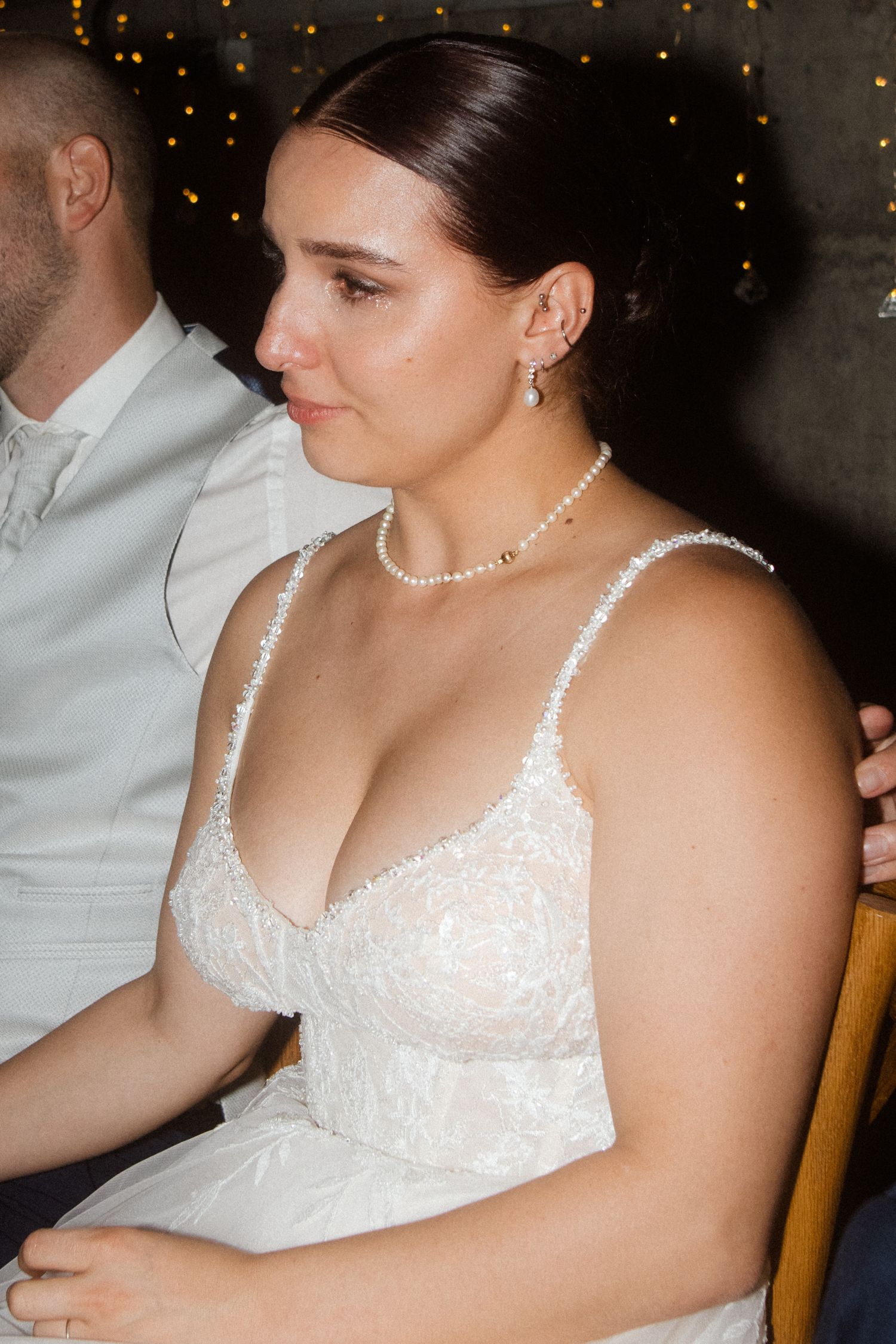 A close-up shot of elegant wedding attire with pearl necklace and lace details.
