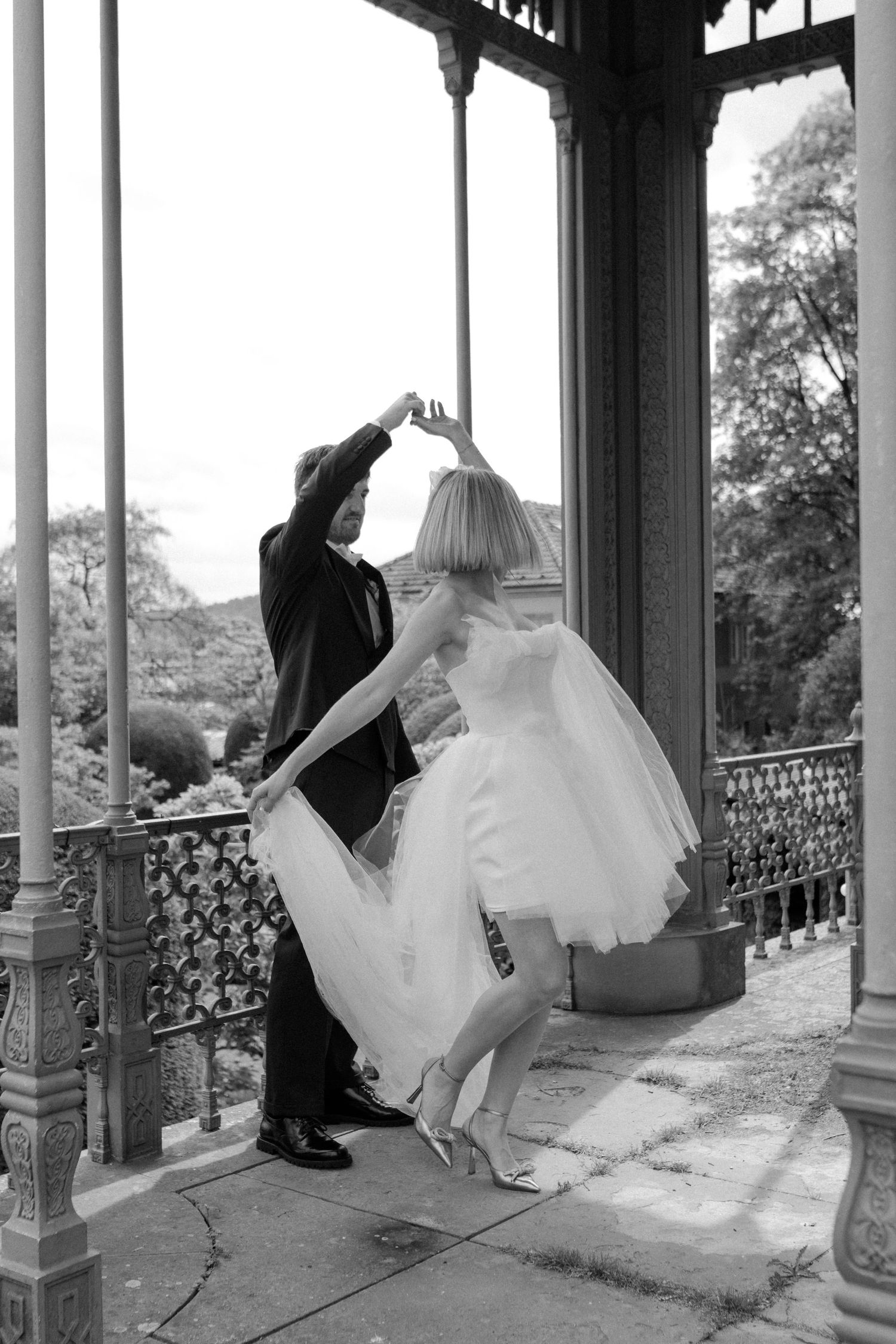 Black and white photo of a dancing couple on a vintage veranda.