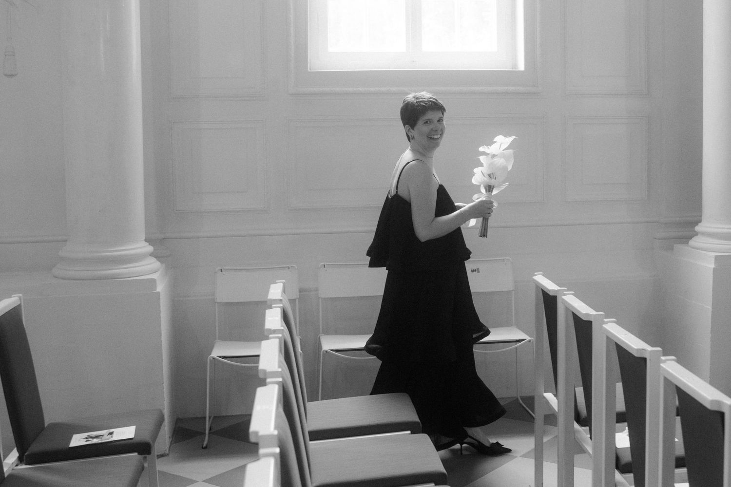 A black and white photo of an elegant evening gown in a classical church interior.