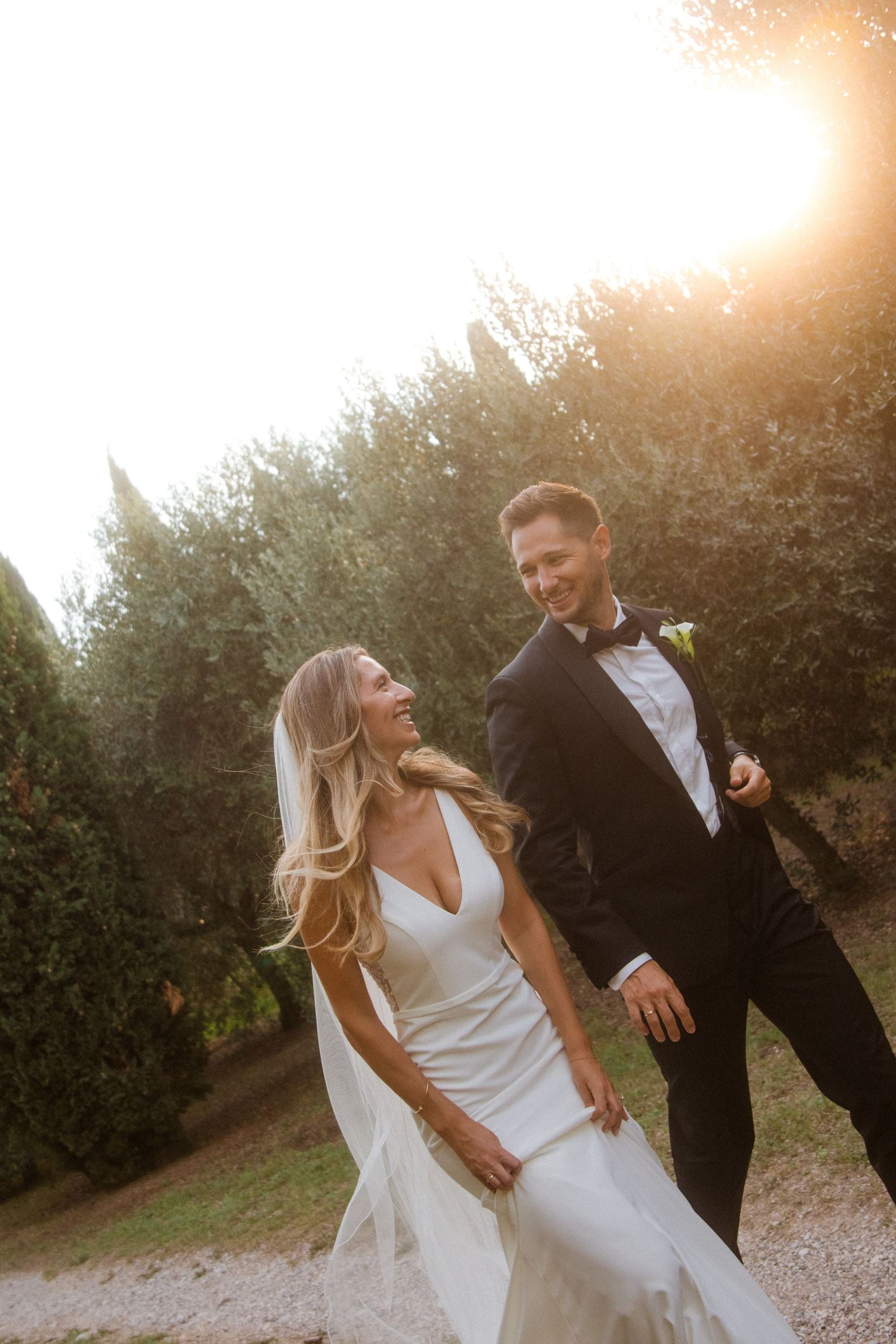 Candid wedding photo of a couple laughing together during golden hour.