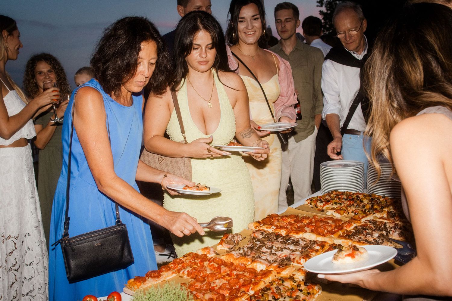 Guests mingling and enjoying refreshments at an outdoor evening party.