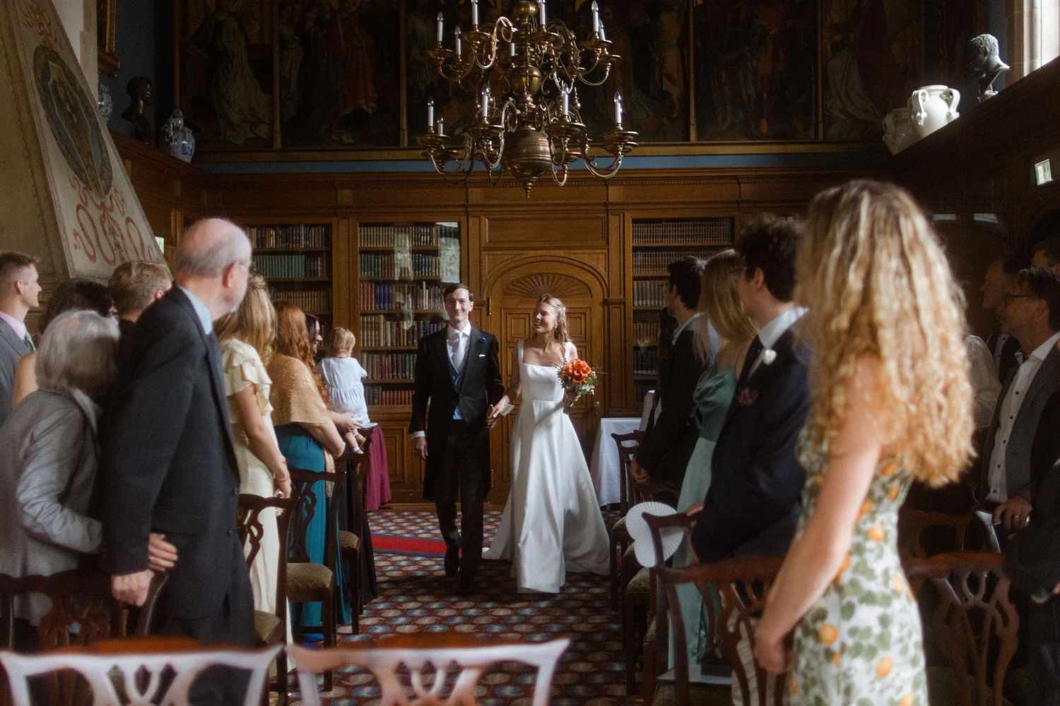 An ornate ballroom with chandeliers and classic decor serves as a wedding reception venue.